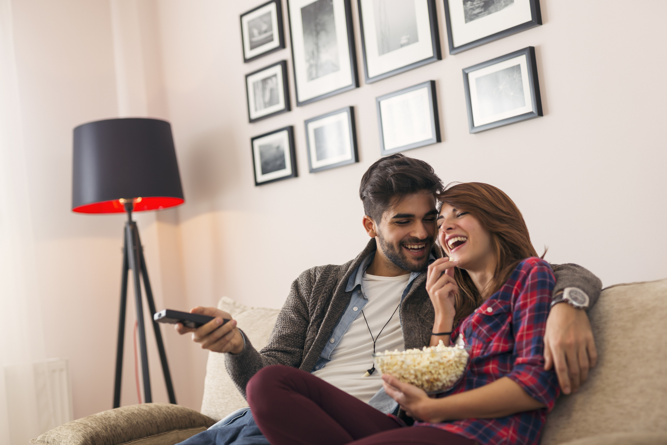Couple watching TV and eating popcorn