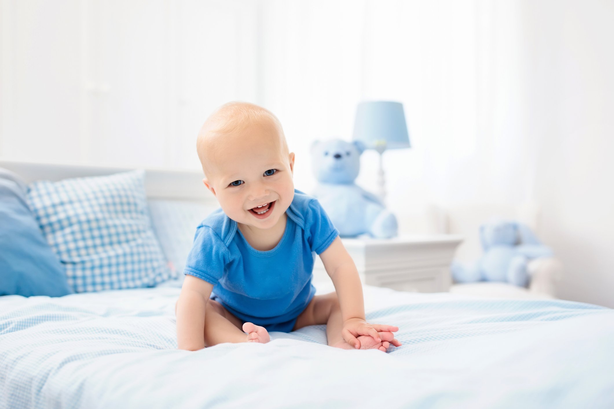 Little baby boy on white bed