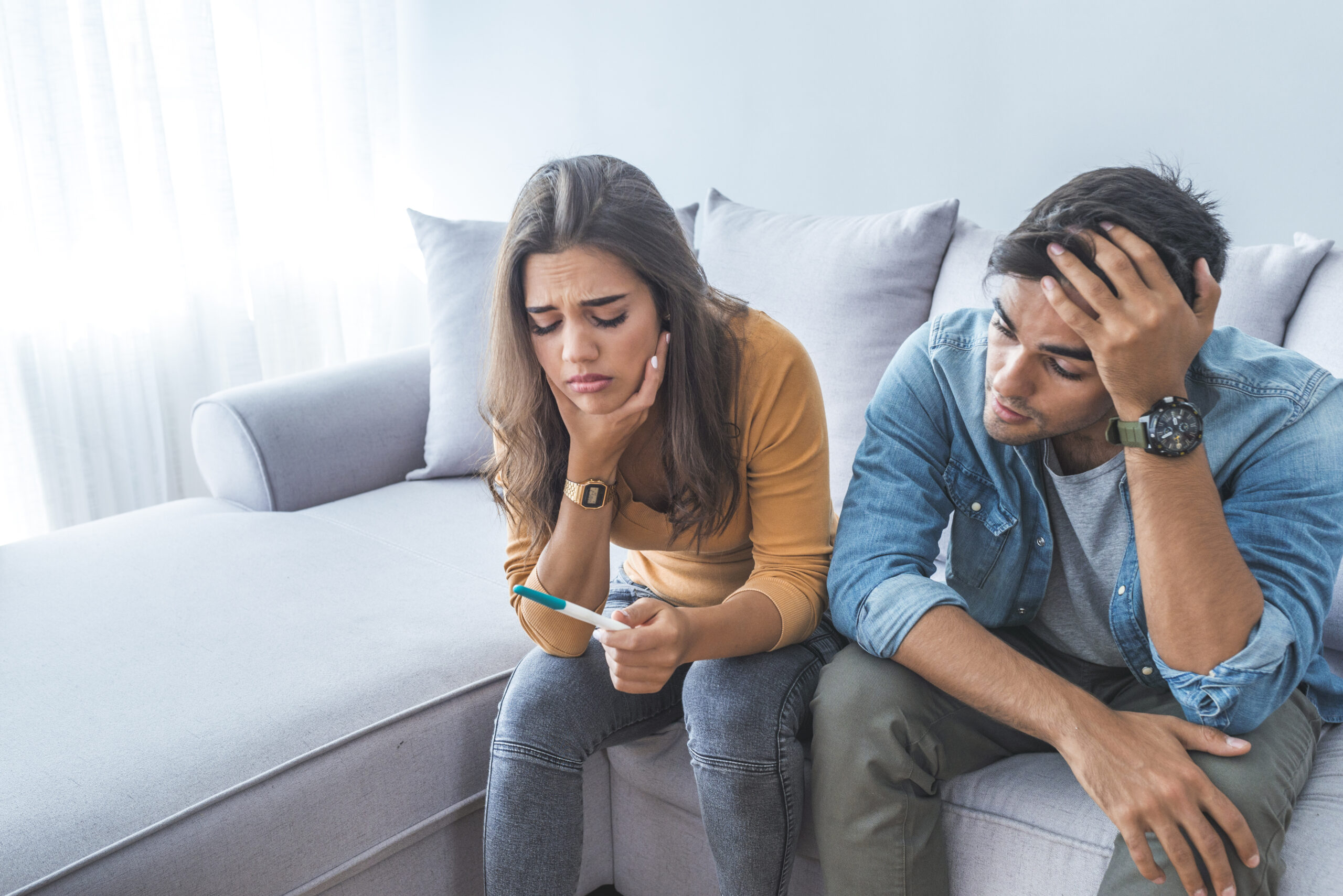 couple sad looking at pregnancy test