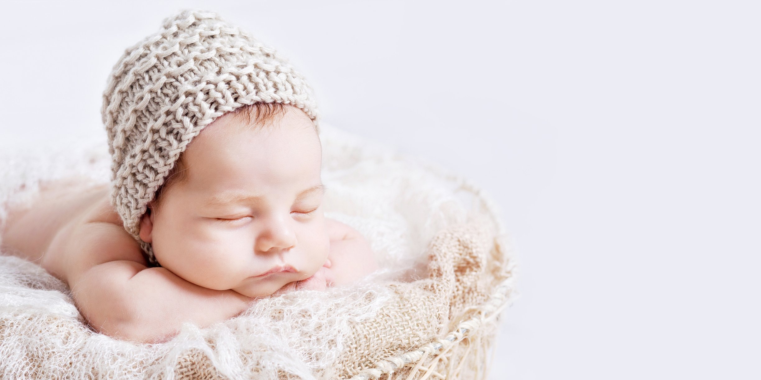 Sweet newborn baby sleeps. Newborn boy folded handles in a basket. Copy space