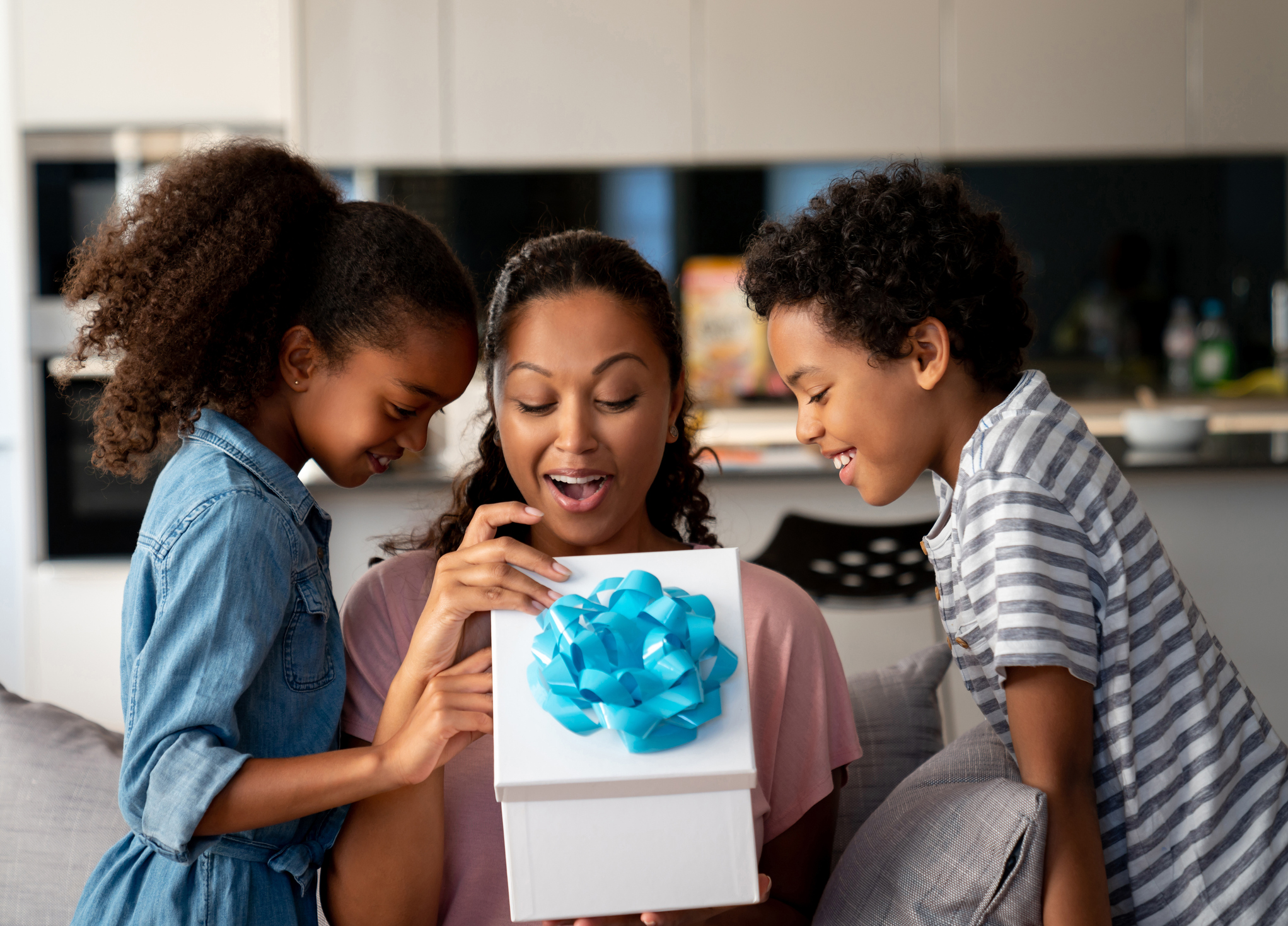 mom opening present with kids