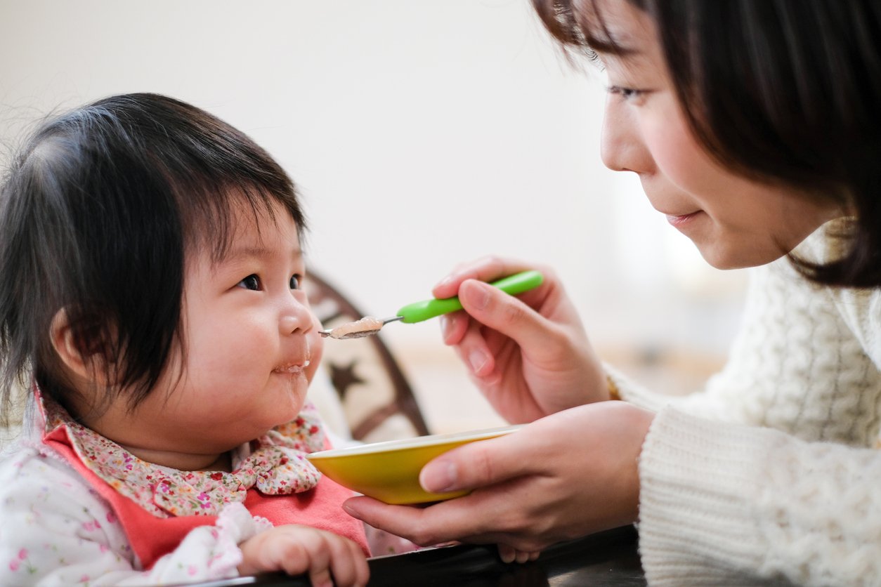 Mother feeding food to baby