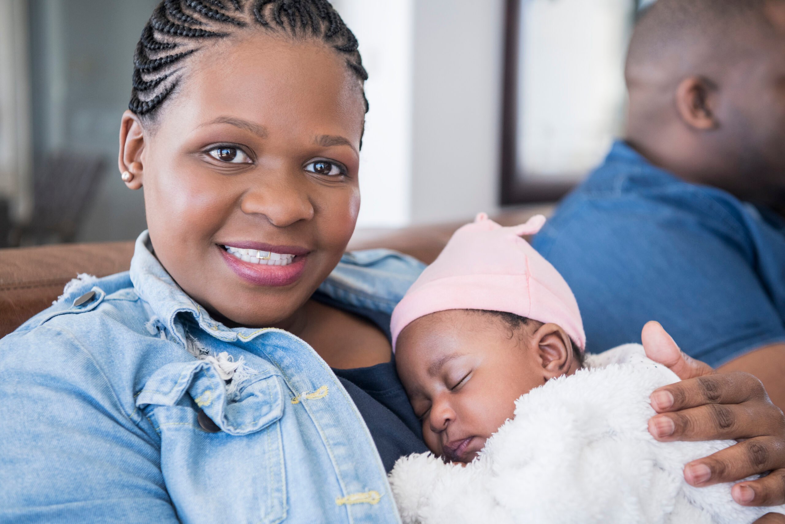 Mother holding baby girl and smiling towards camera