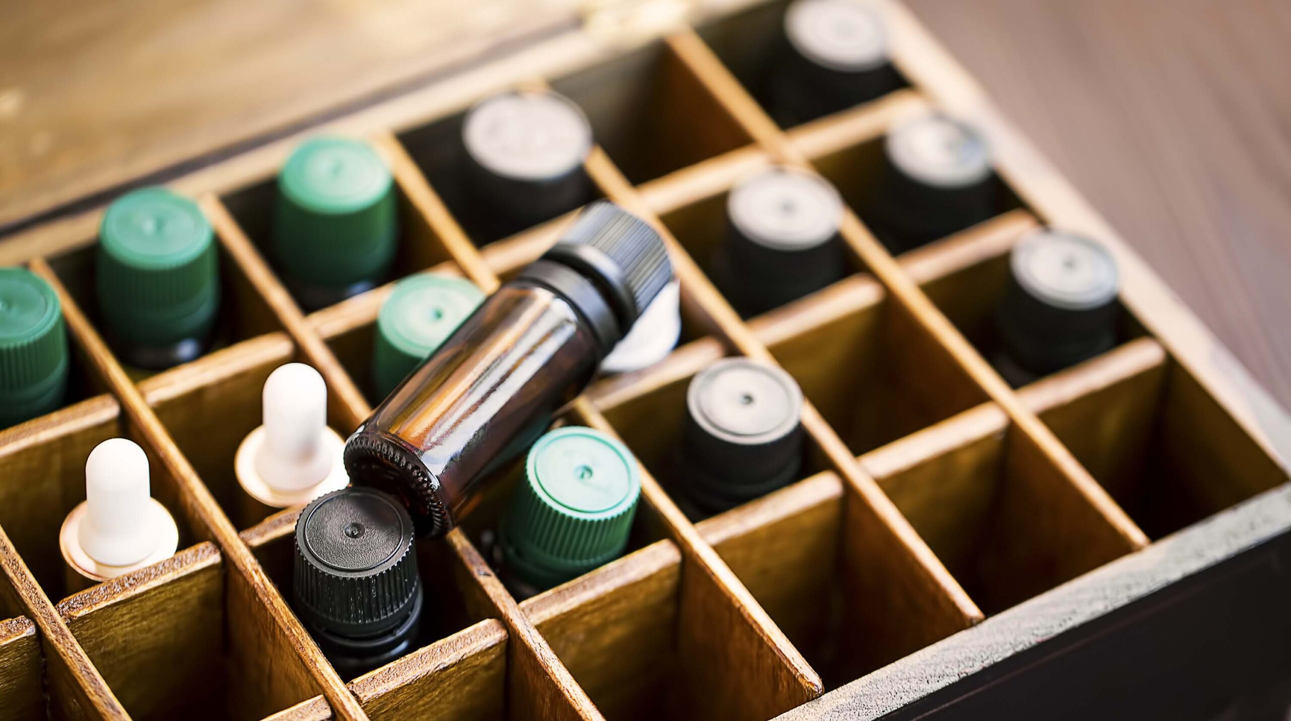Aromatherapy essential oils in wooden box. Herbal alternative medicine with essential oils bottles in wooden box, healthy organic natural therapy
