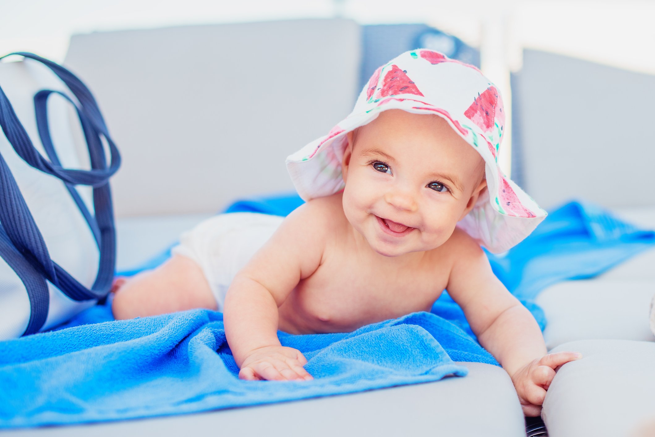Cute baby girl in a sun hat on a beach chaise lounge