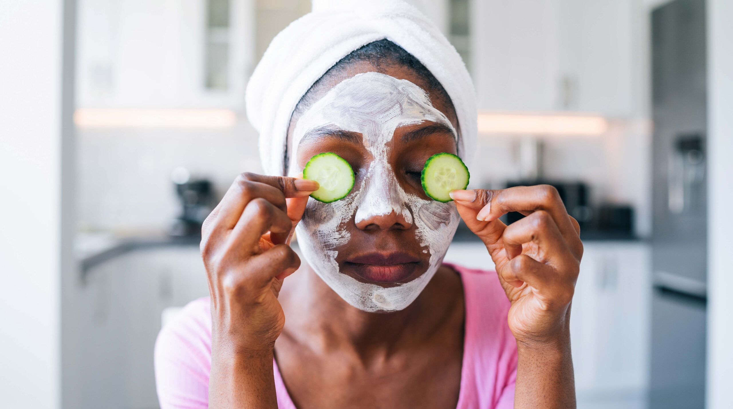 Beautiful young afro woman with cucumber on eyes