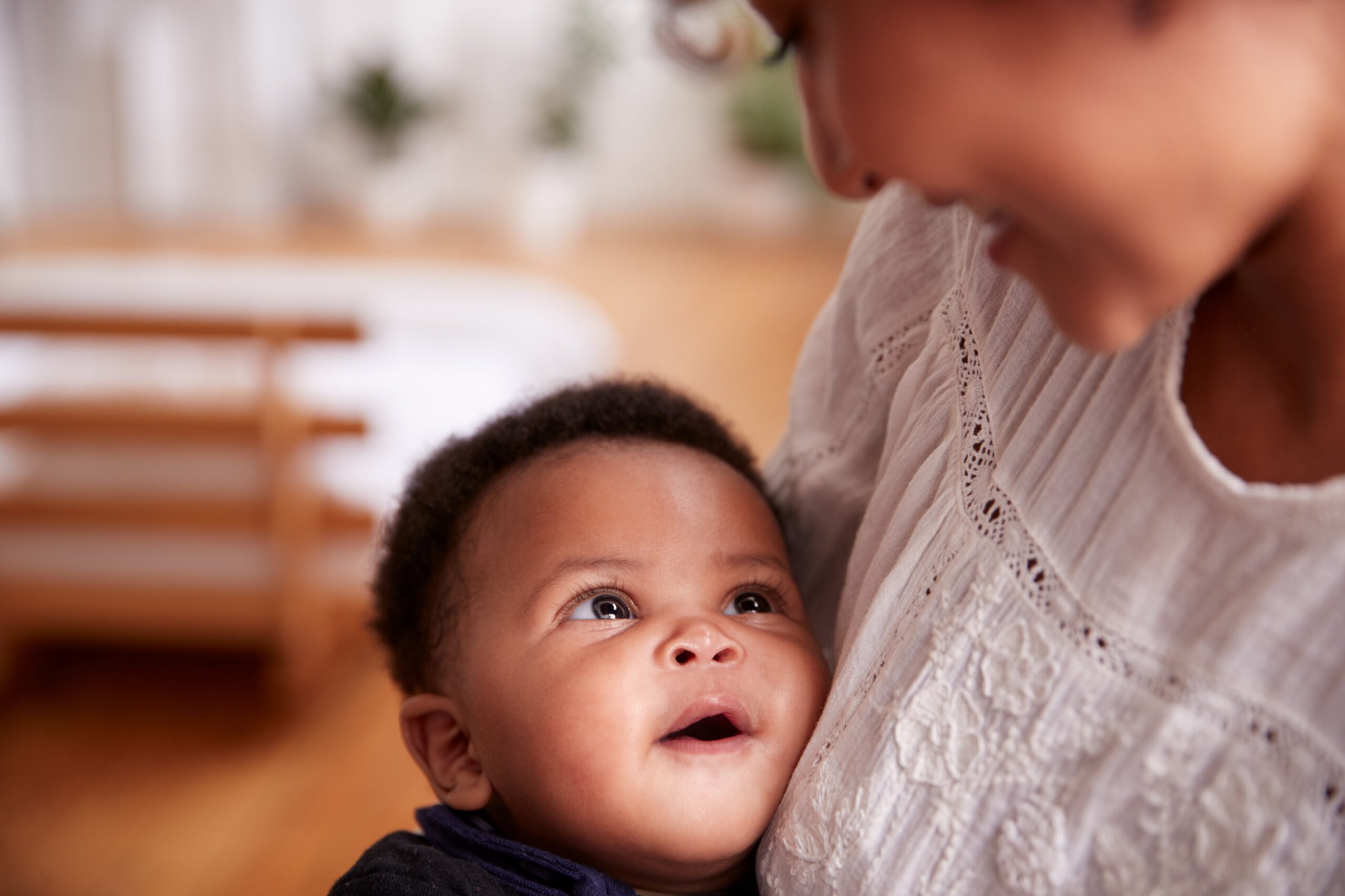 Loving Mother Holding Newborn Baby At Home In Loft Apartment