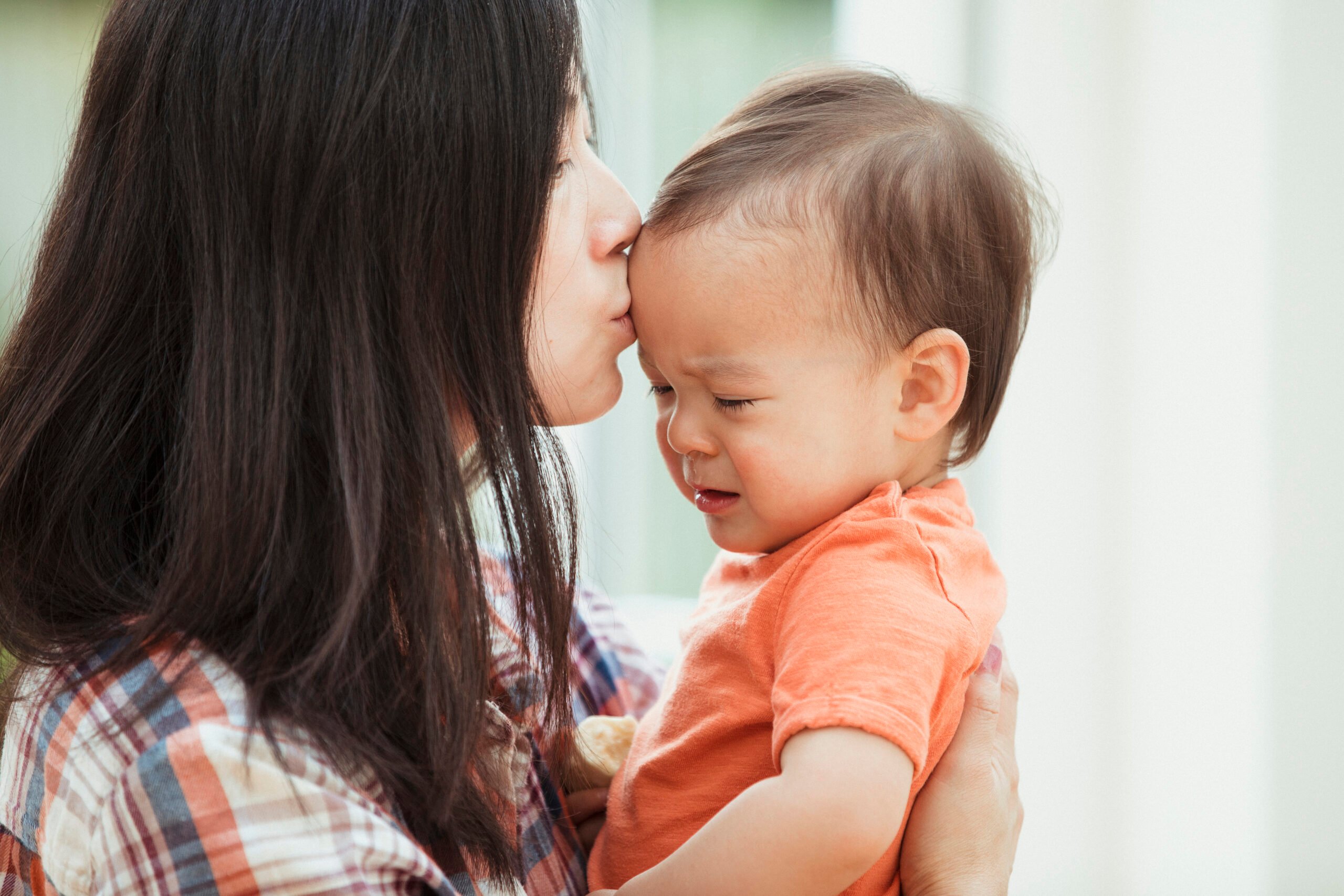 mom kissing crying baby