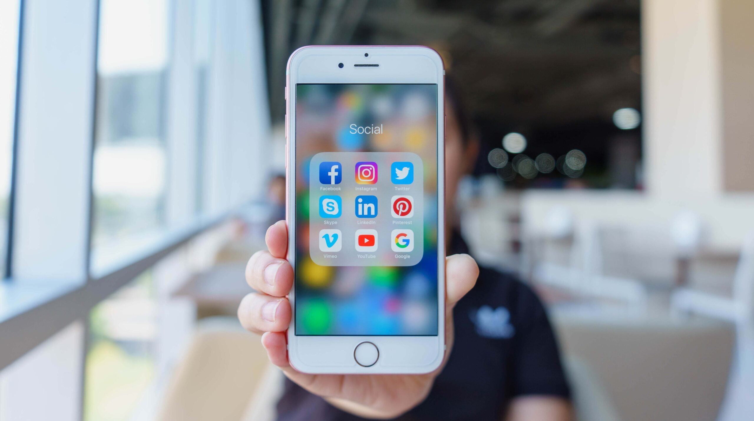 Woman holding Apple iPhone 6S Rose Gold with icons of social media on screen. Social media are most popular tool. Smartphone life style. Starting social media app.