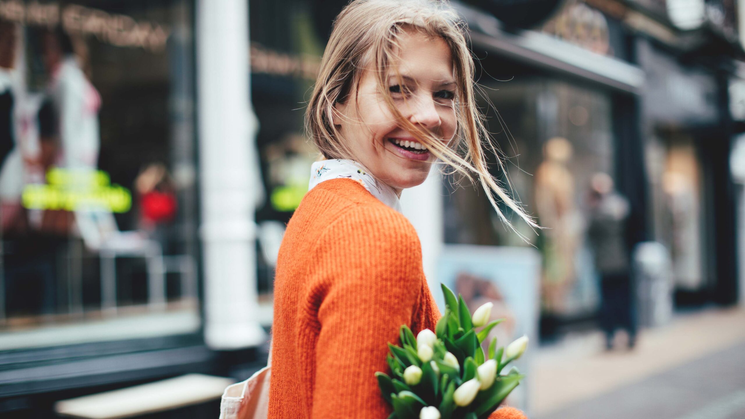 Woman walking outside with tulips self-care