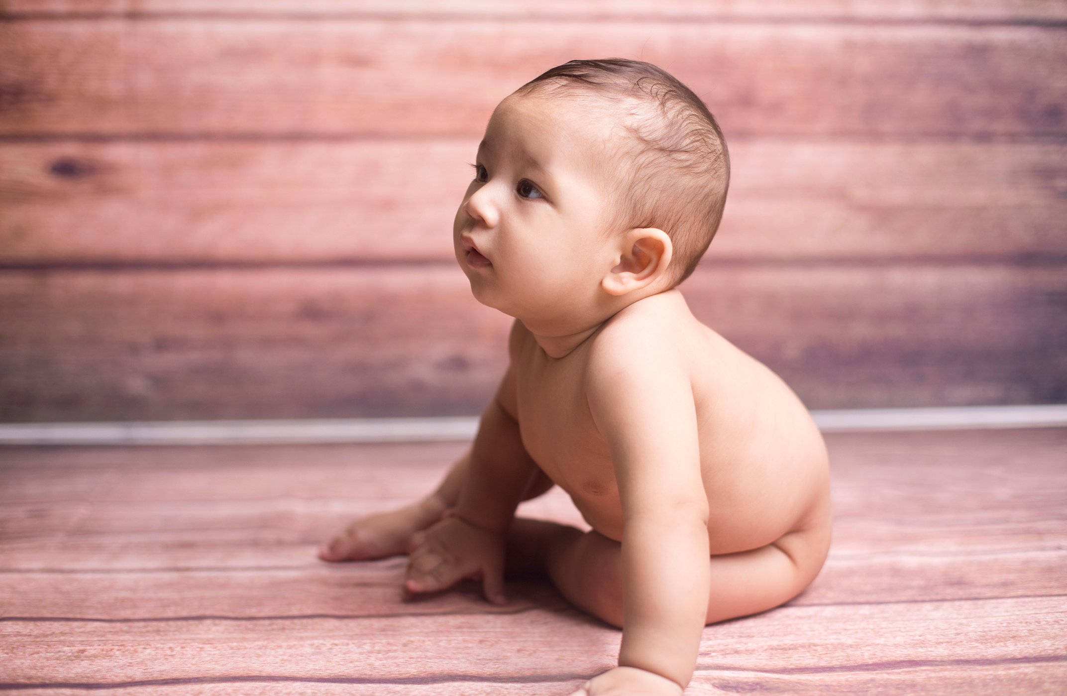Naked baby boy on floor