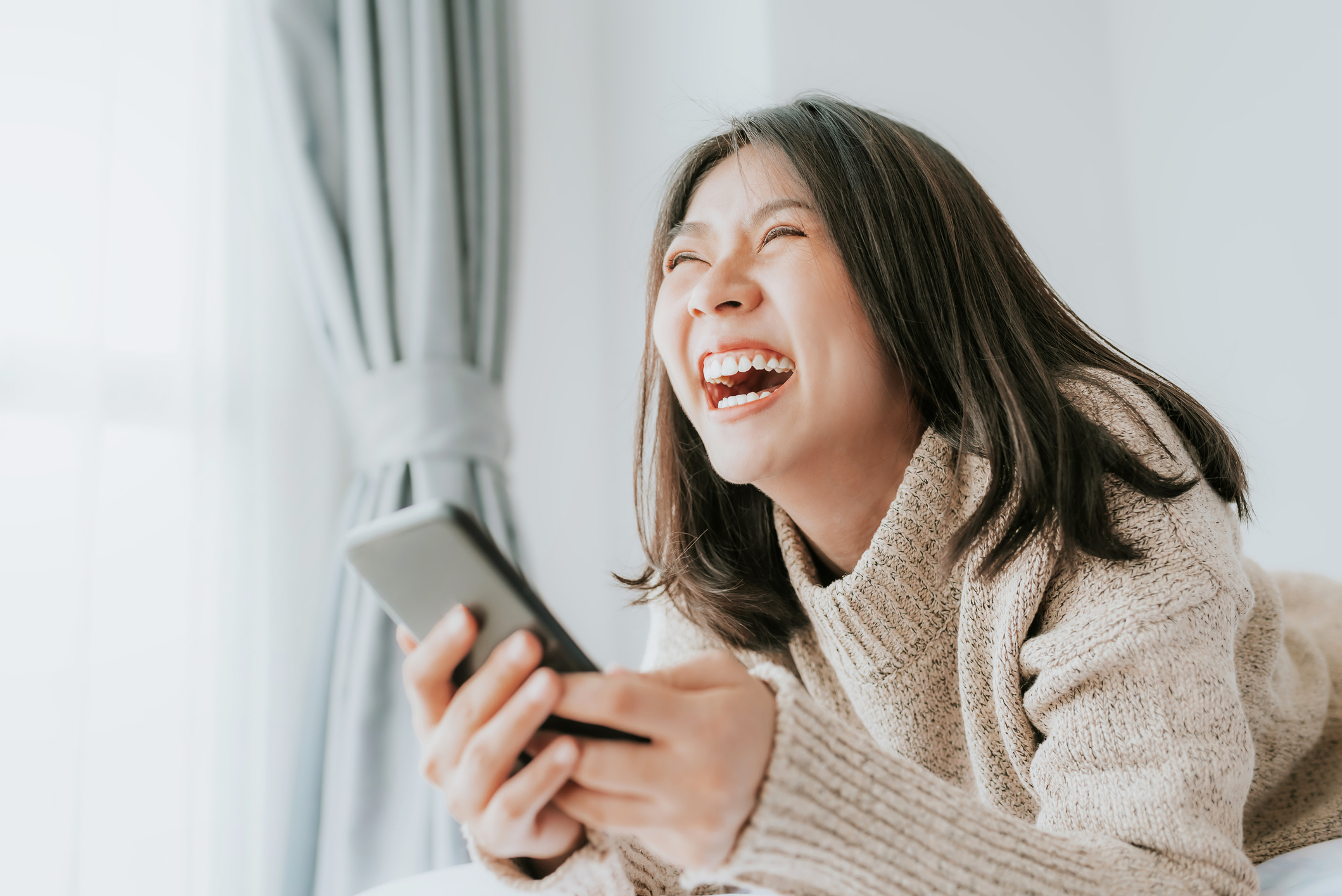 woman laughing at text
