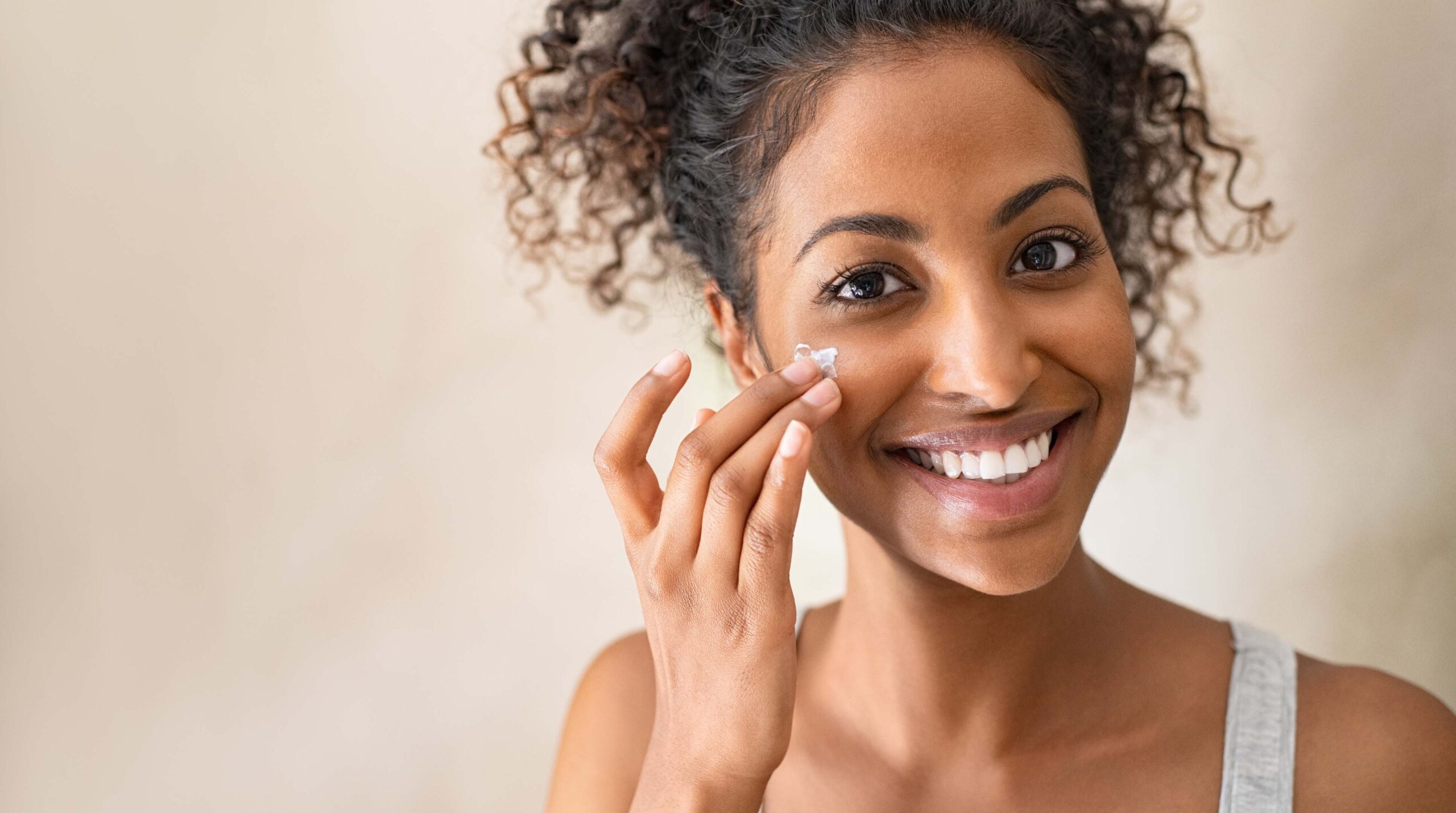 Beautiful girl applying face cream