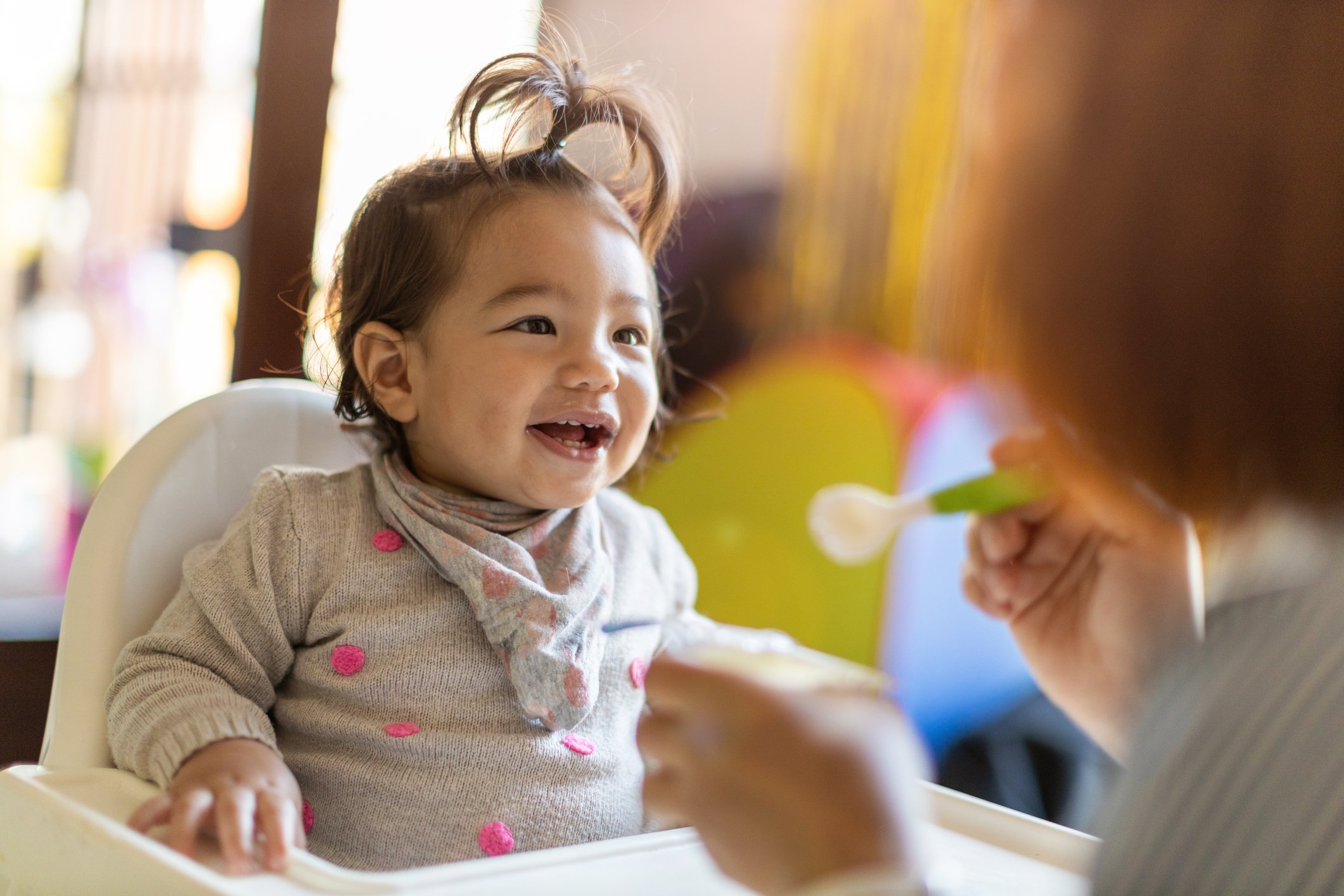 Mother feeding her baby with spoon