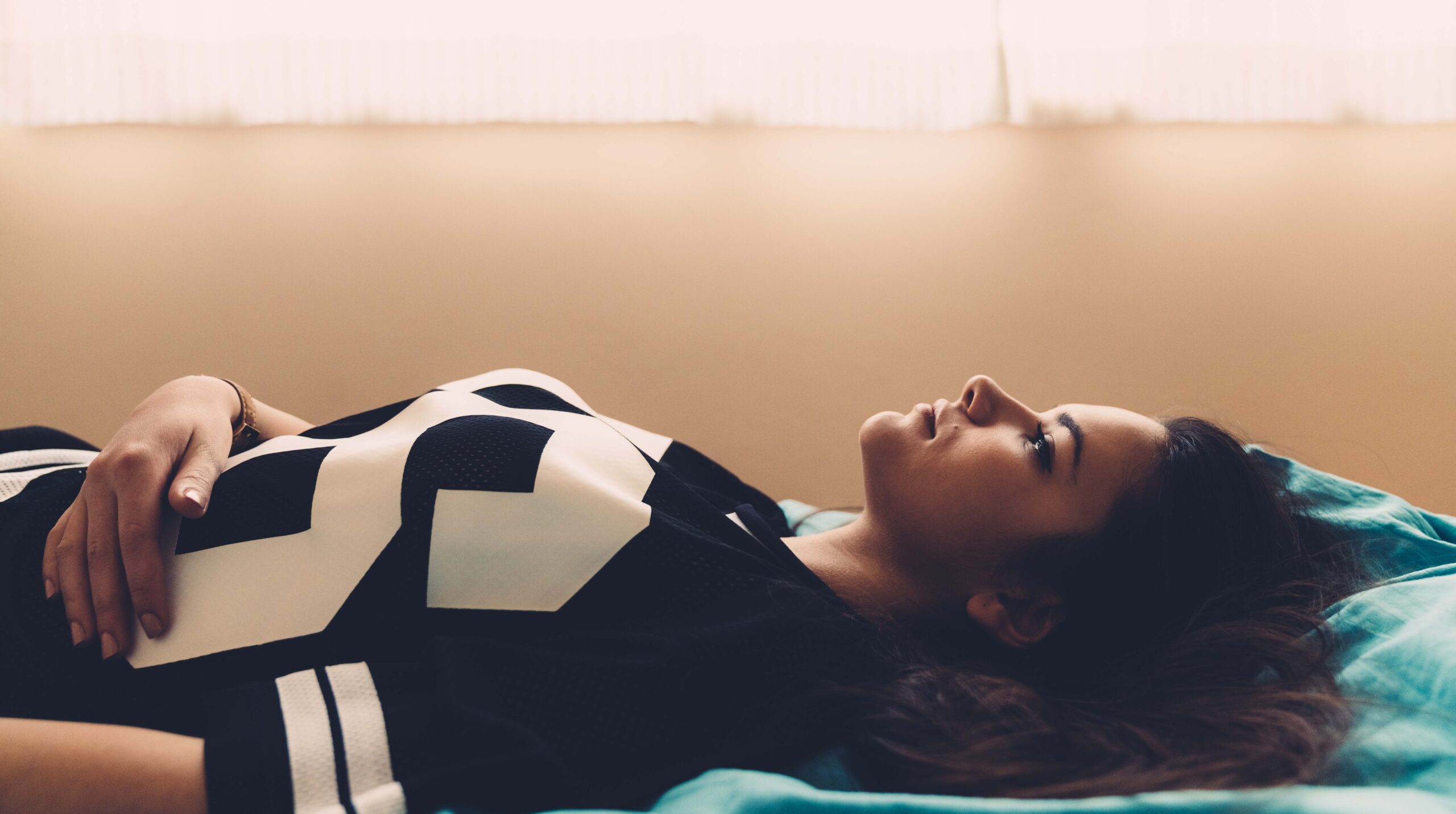 Depressed teenage girl lying down in bed