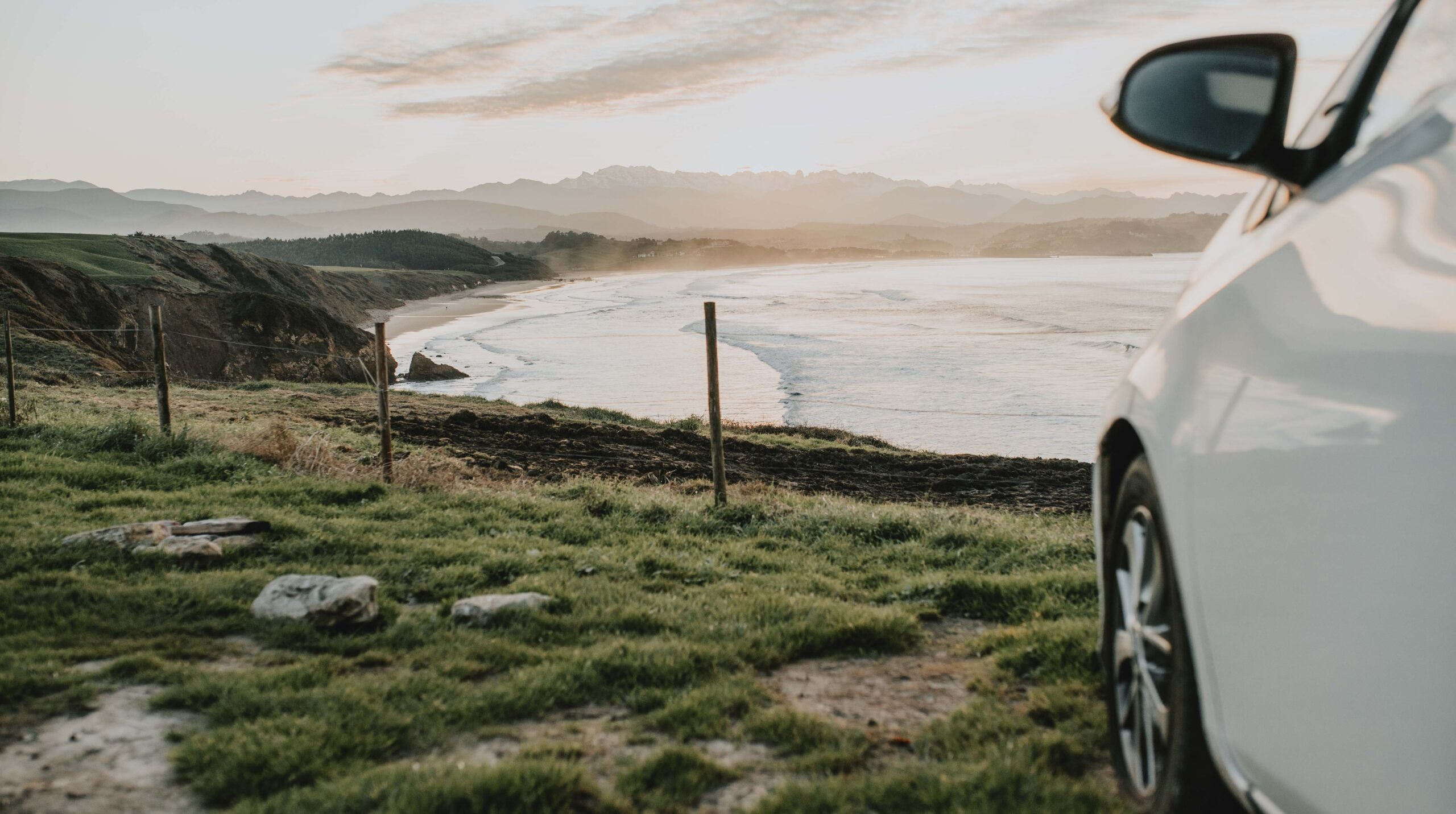Car by a beach at sunset
