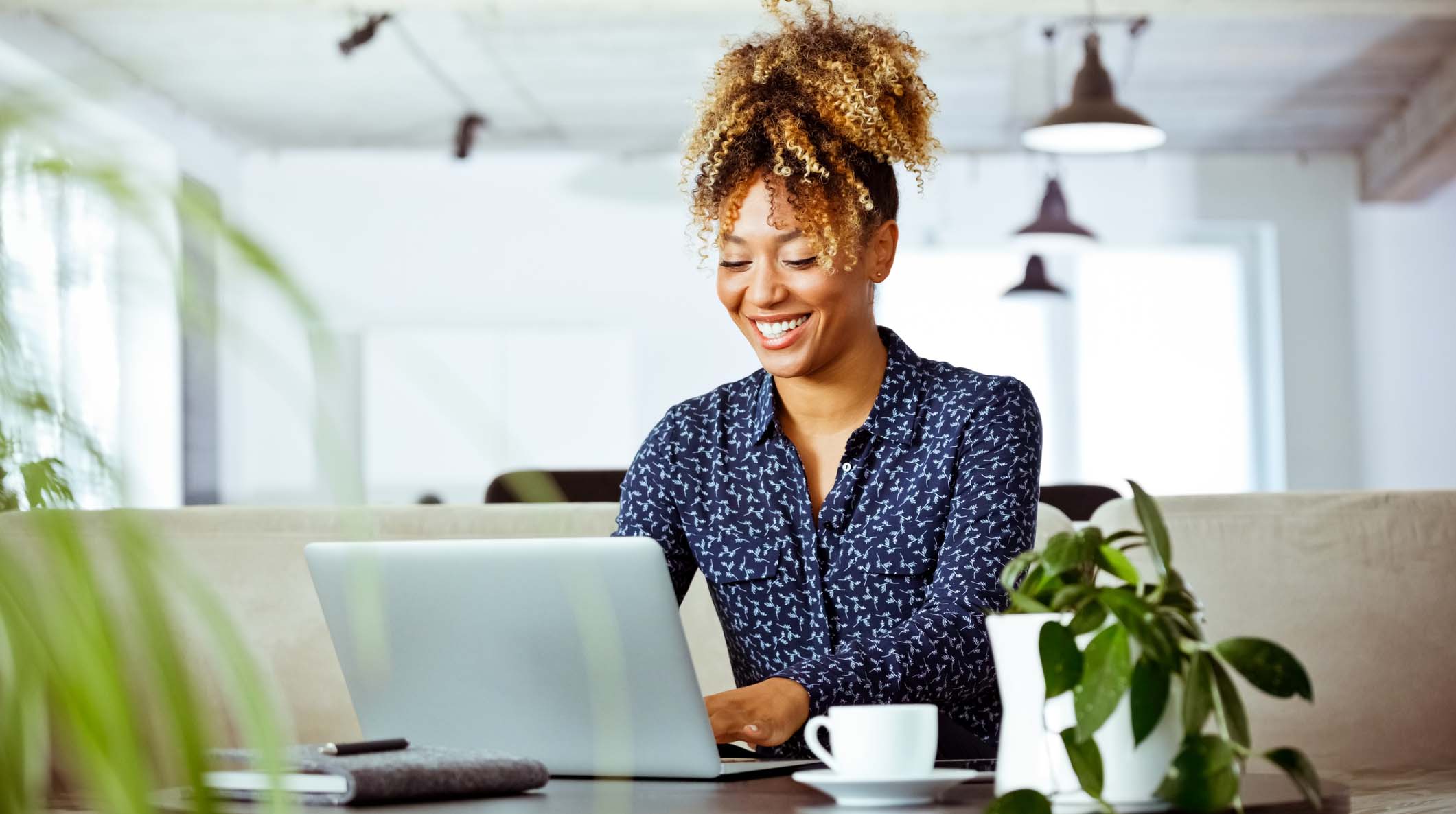 Smiling businesswoman using laptop in office