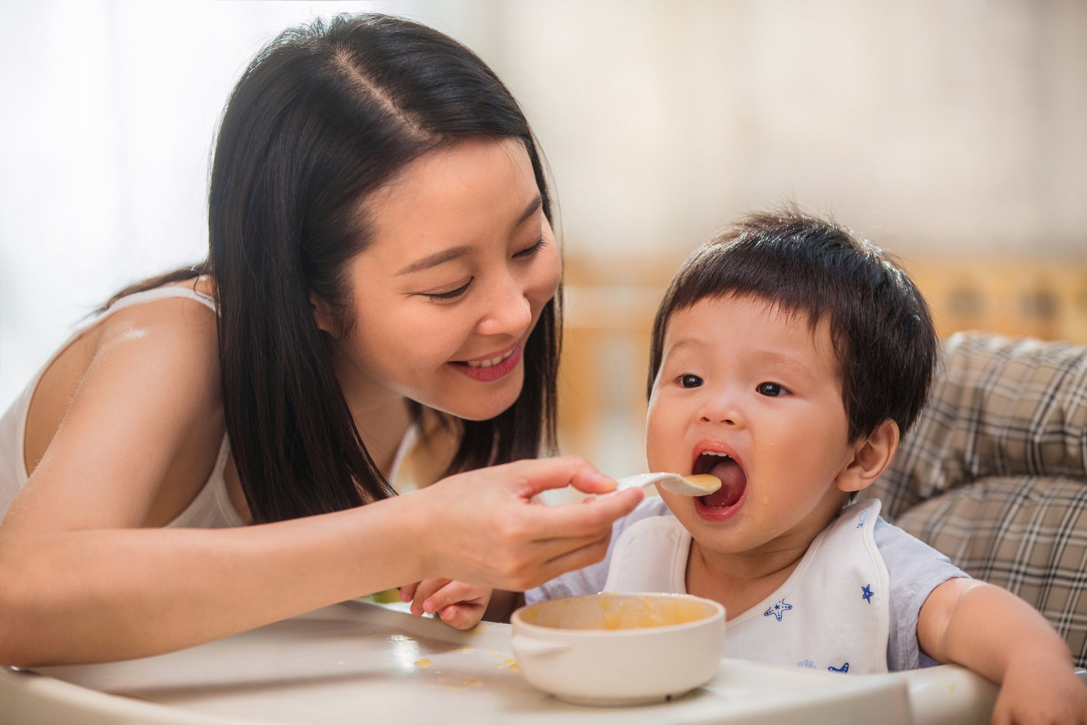 mom feeding baby solid food