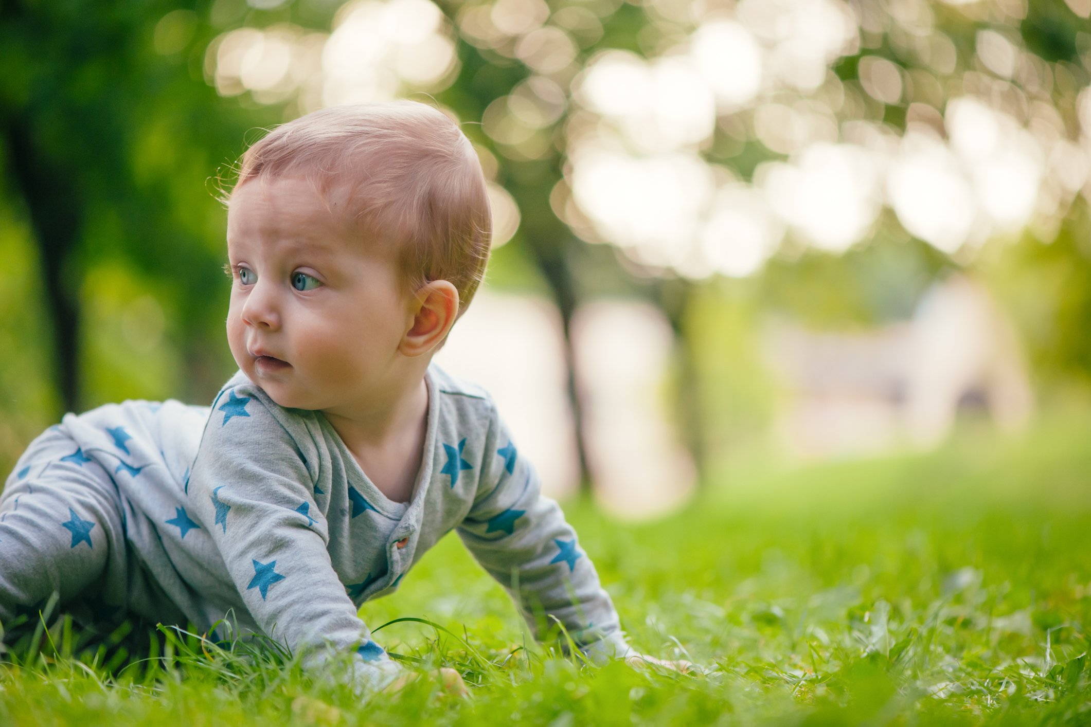 Baby boy playing with bubbles in summer park