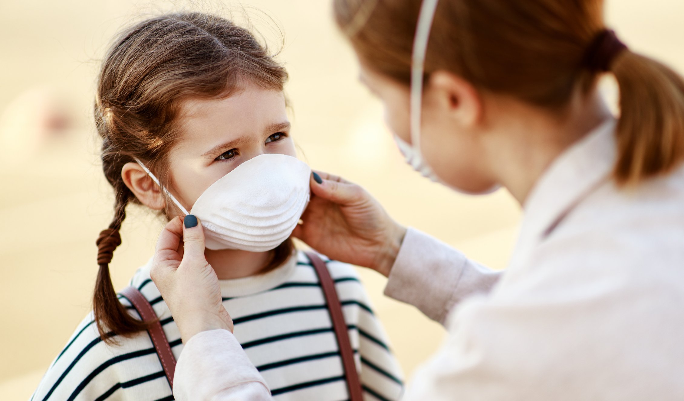mom-putting-mask-daughter