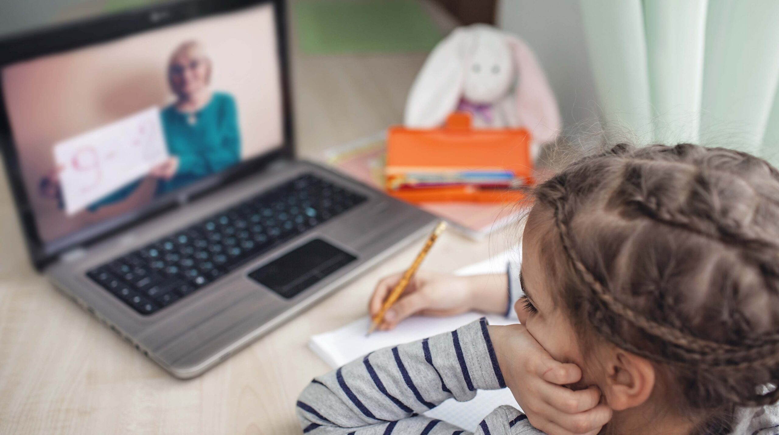 Pretty stylish schoolgirl studying math during her online lesson at home, self-isolation