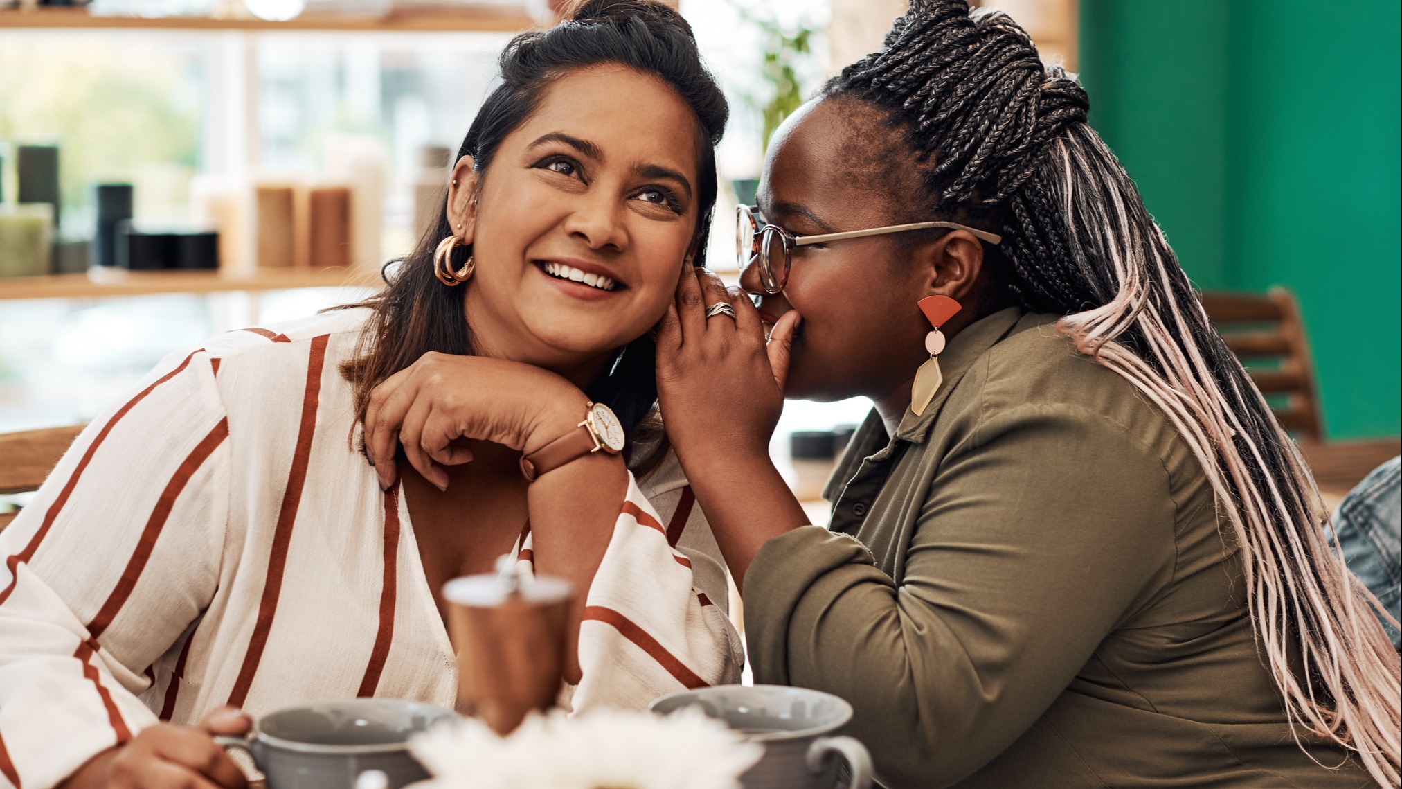 two female friends telling each other secrets