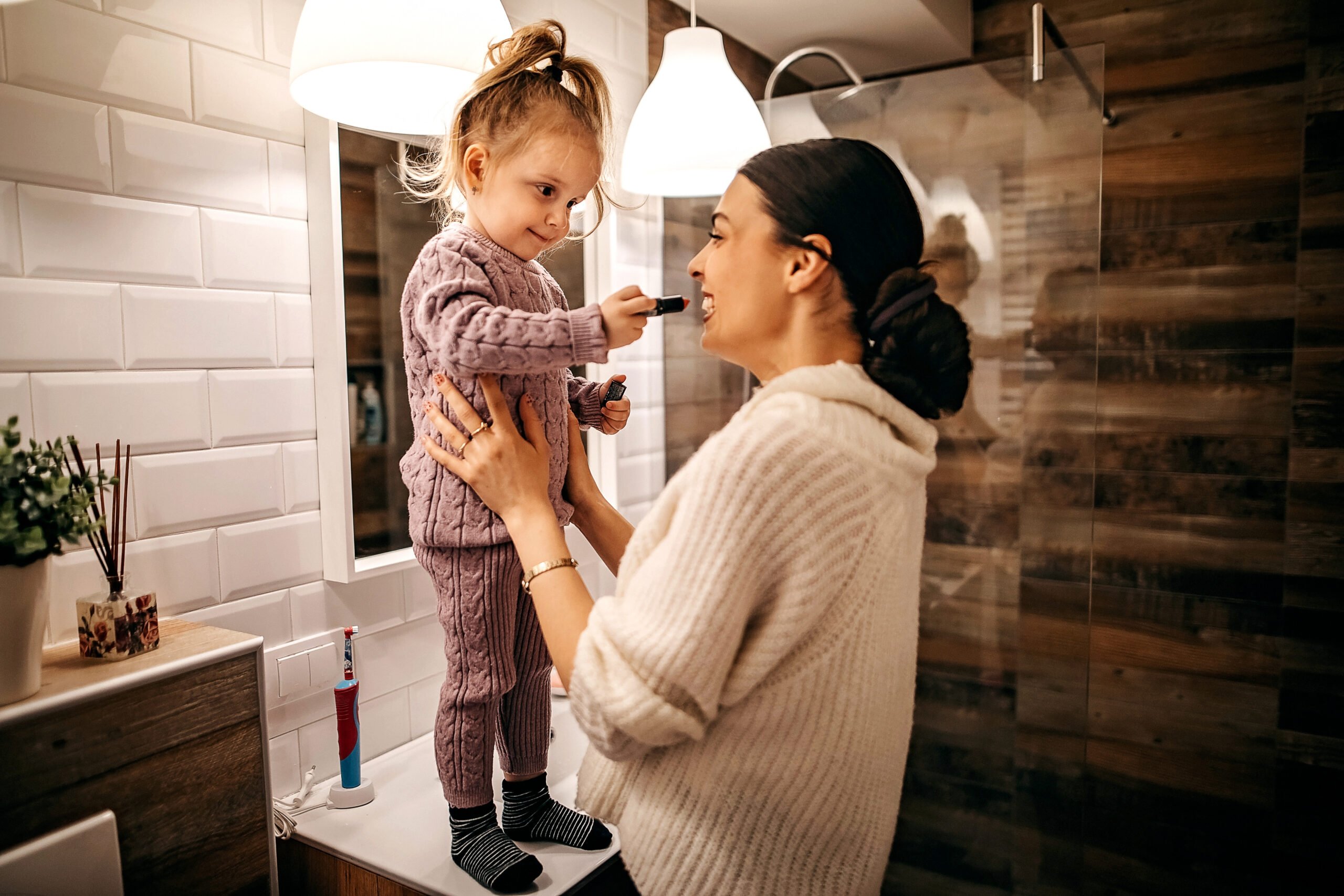 Mother and daughter playing with lipctick