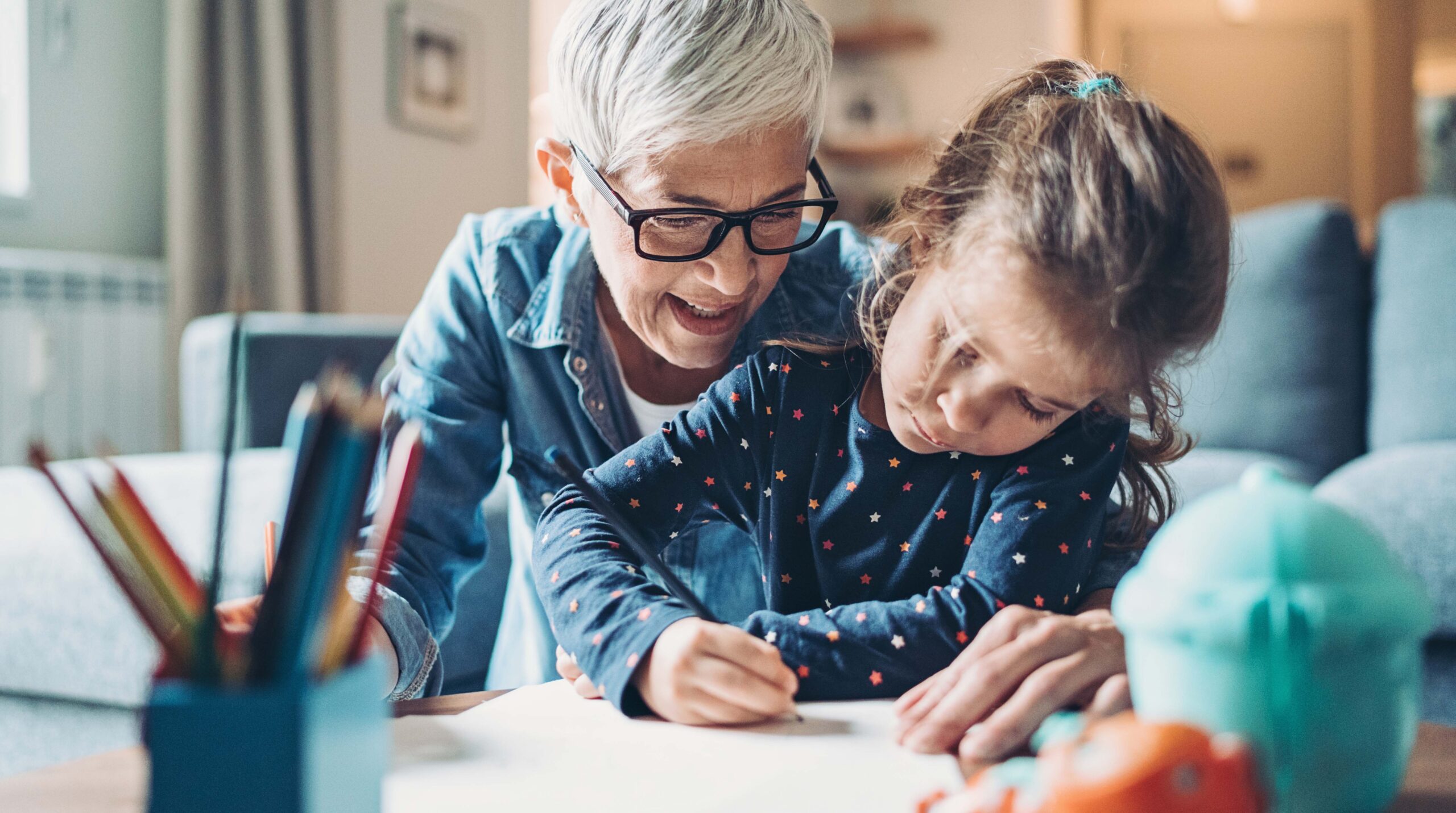 Mature woman teaching a little girl to write