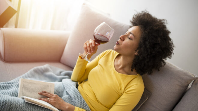 woman relaxing on couch with book