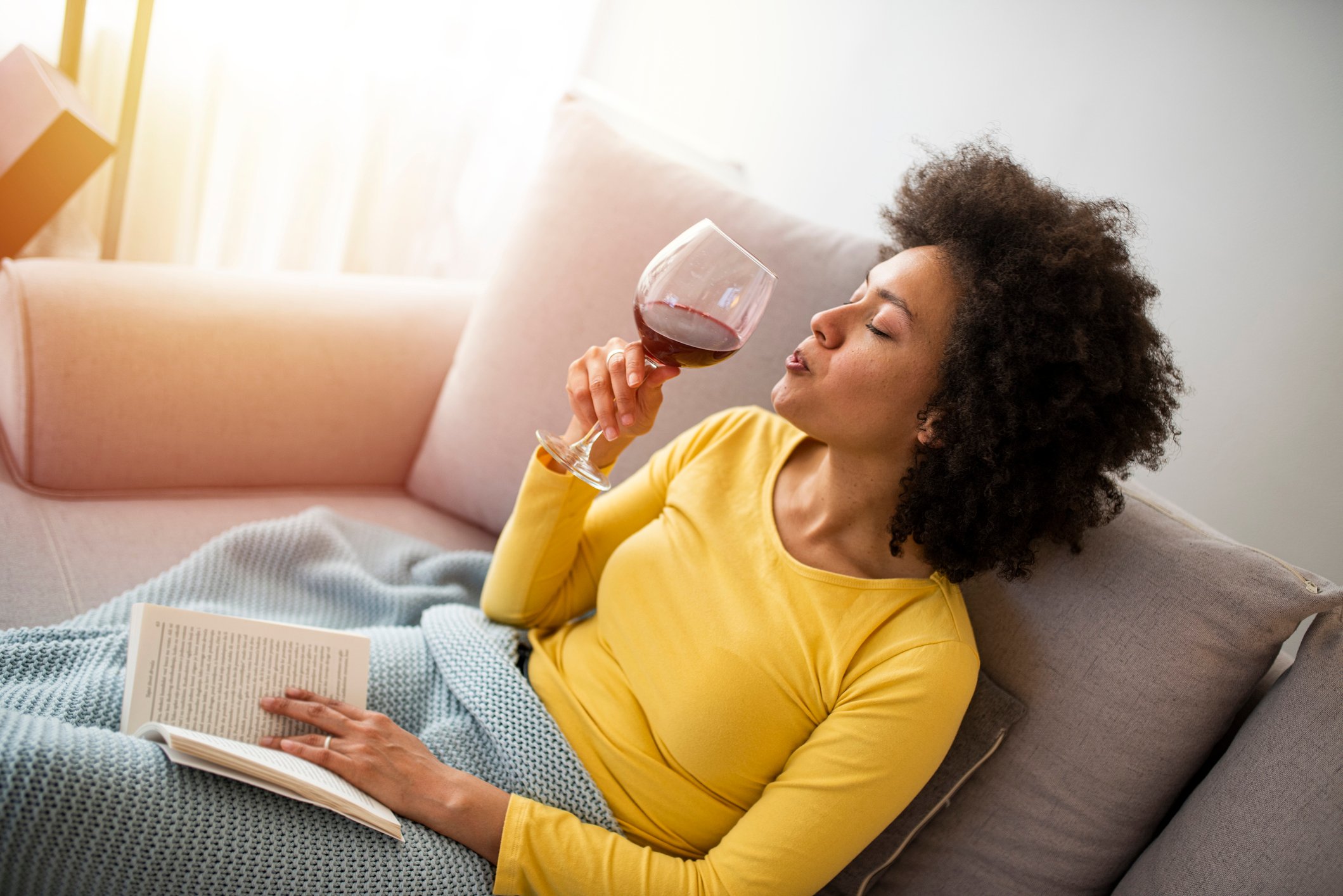 woman relaxing on couch with book