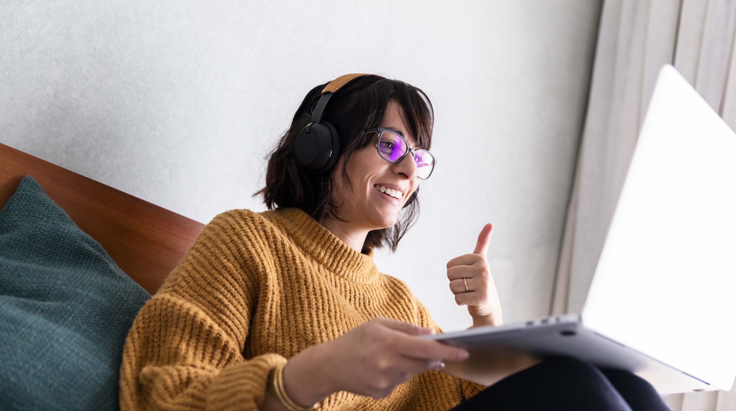 Woman using video conference gives colleagues a thumbs up