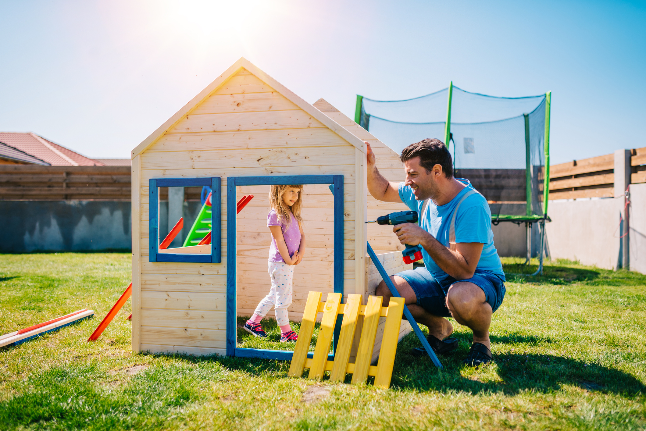 Father and daughter building a wooden house together