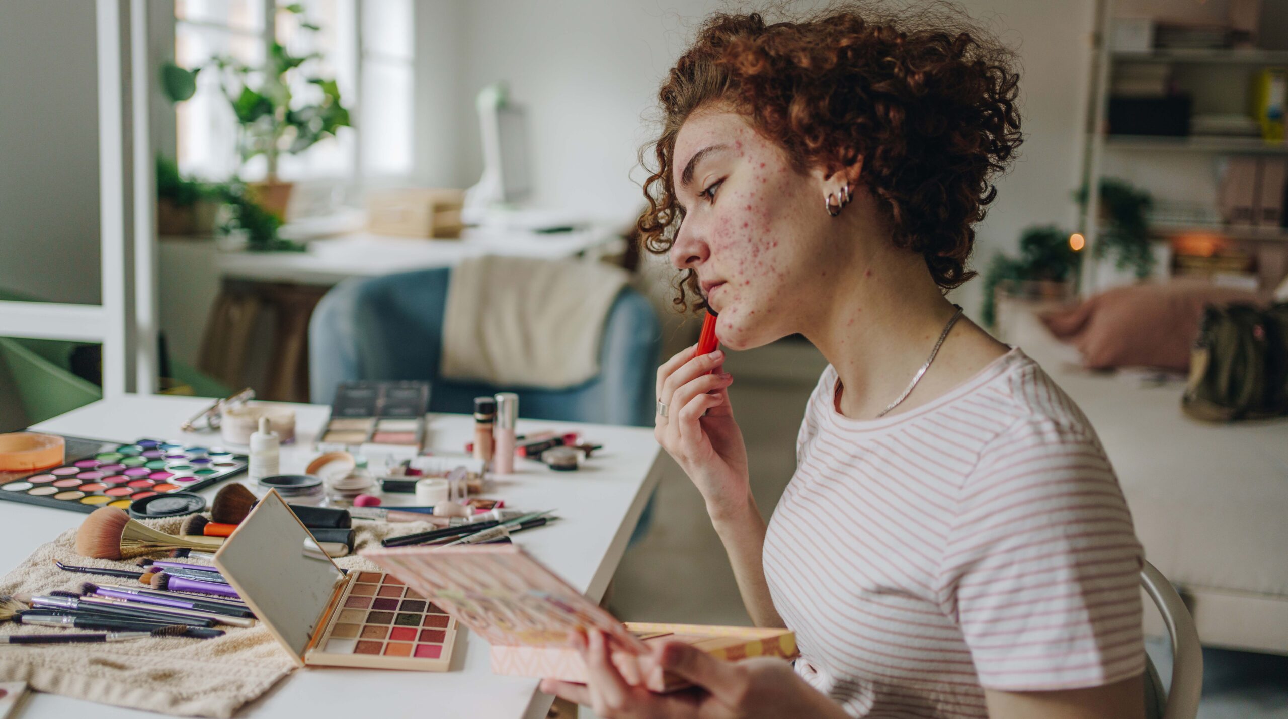 Young woman applying make-up