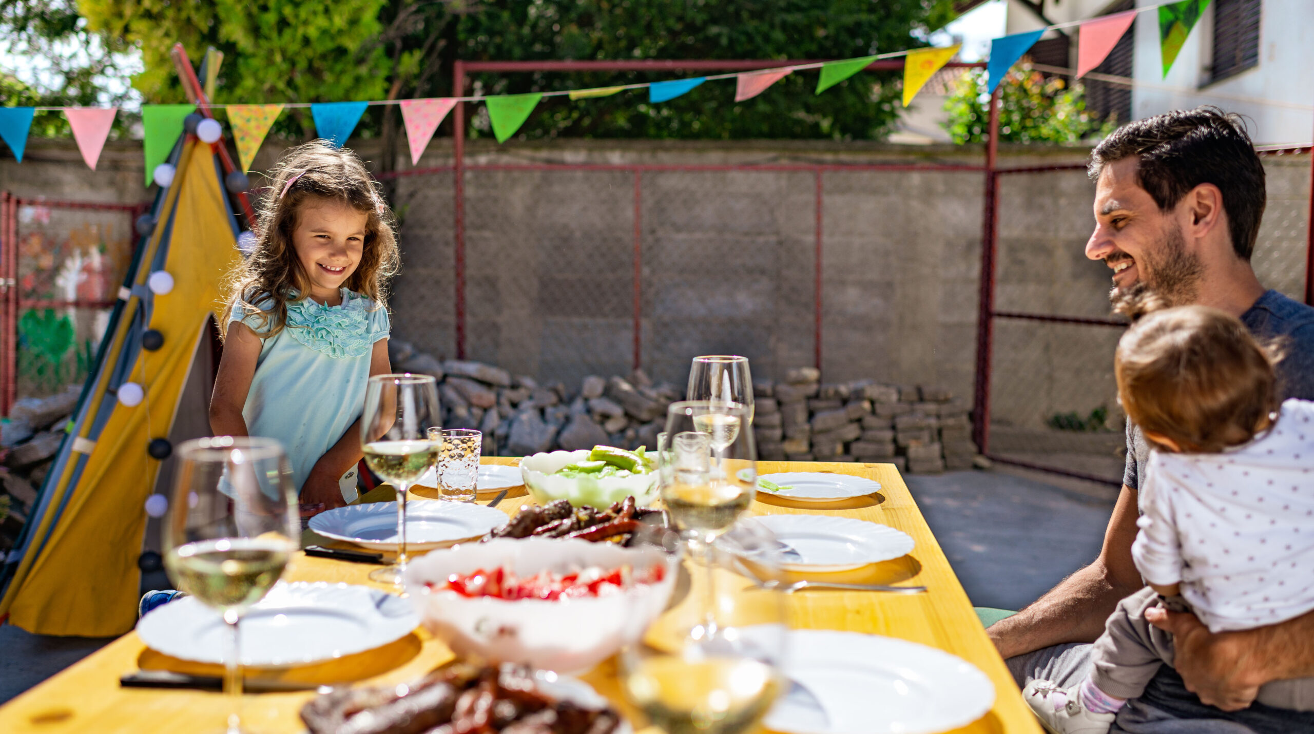 Family enjoying BBQ in front yard