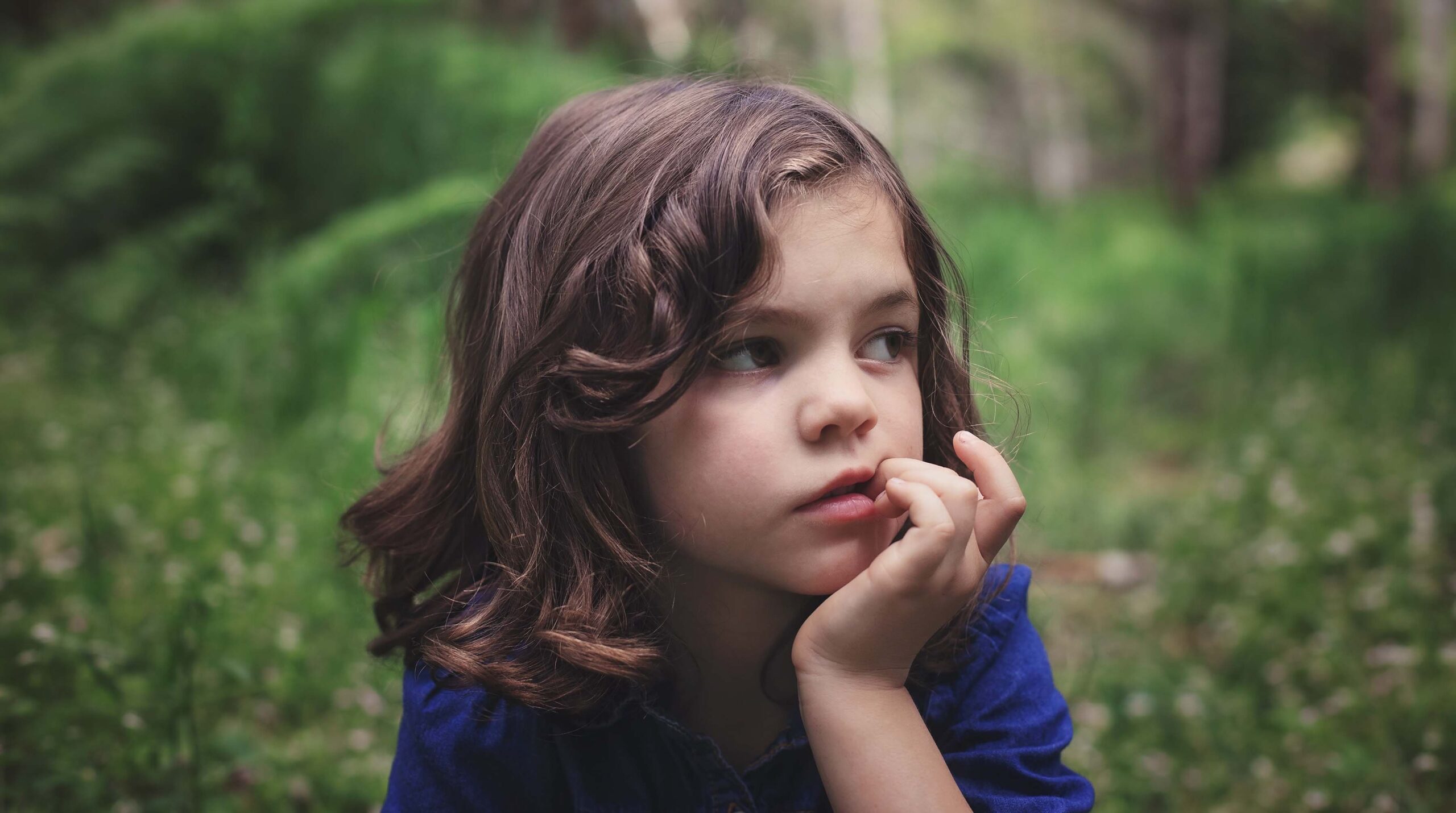 Young girl biting her nails