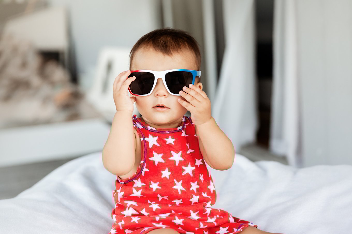 Baby girl wearing sunglasses and red dress on Independence Day on 4th of July