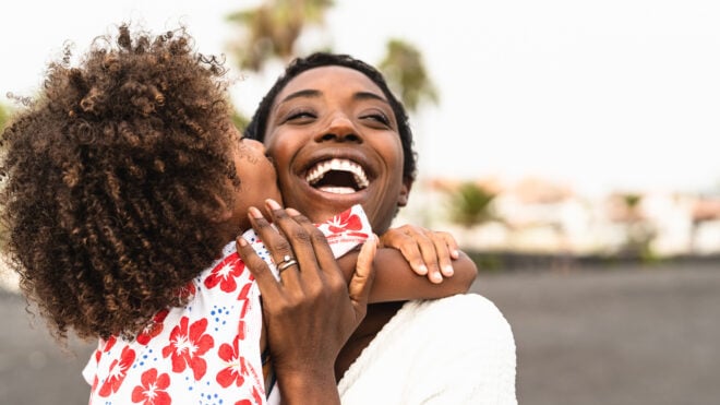 mom hugging girl on beach