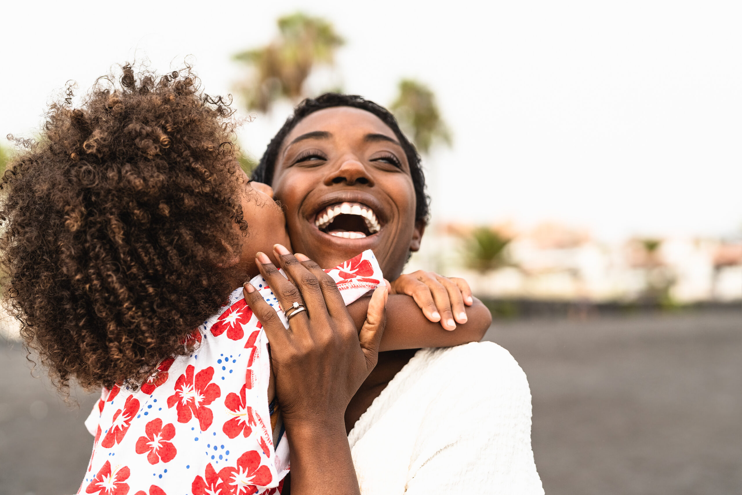 mom hugging girl on beach