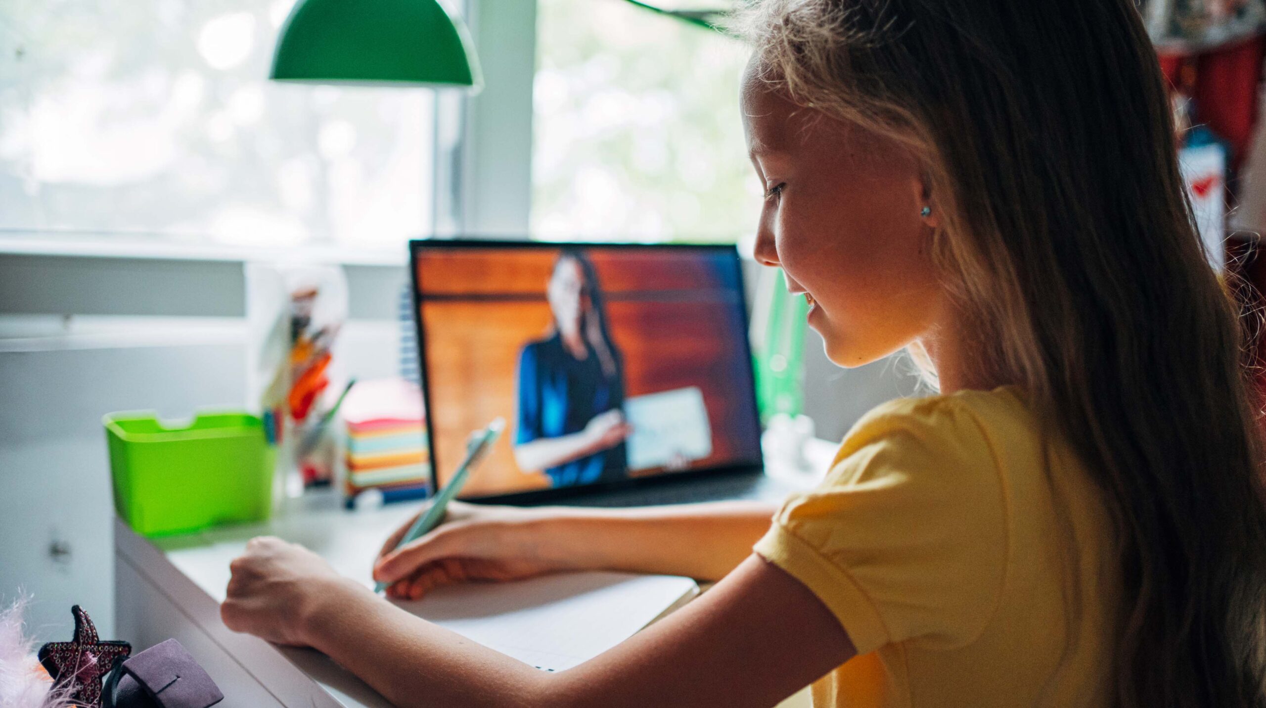 Schoolgirl studying with video online lesson at home.