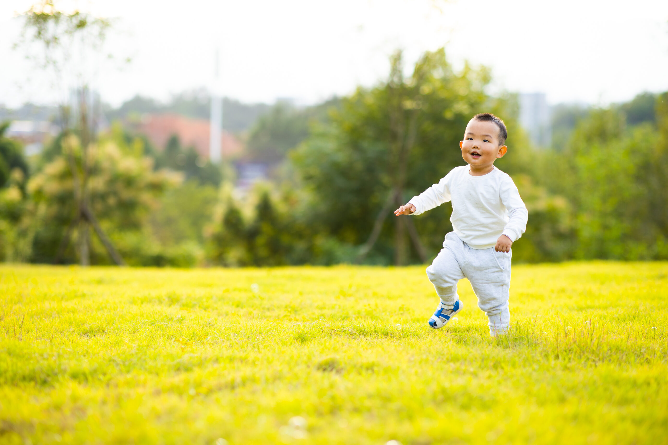 Baby boy running on lawn in autumn