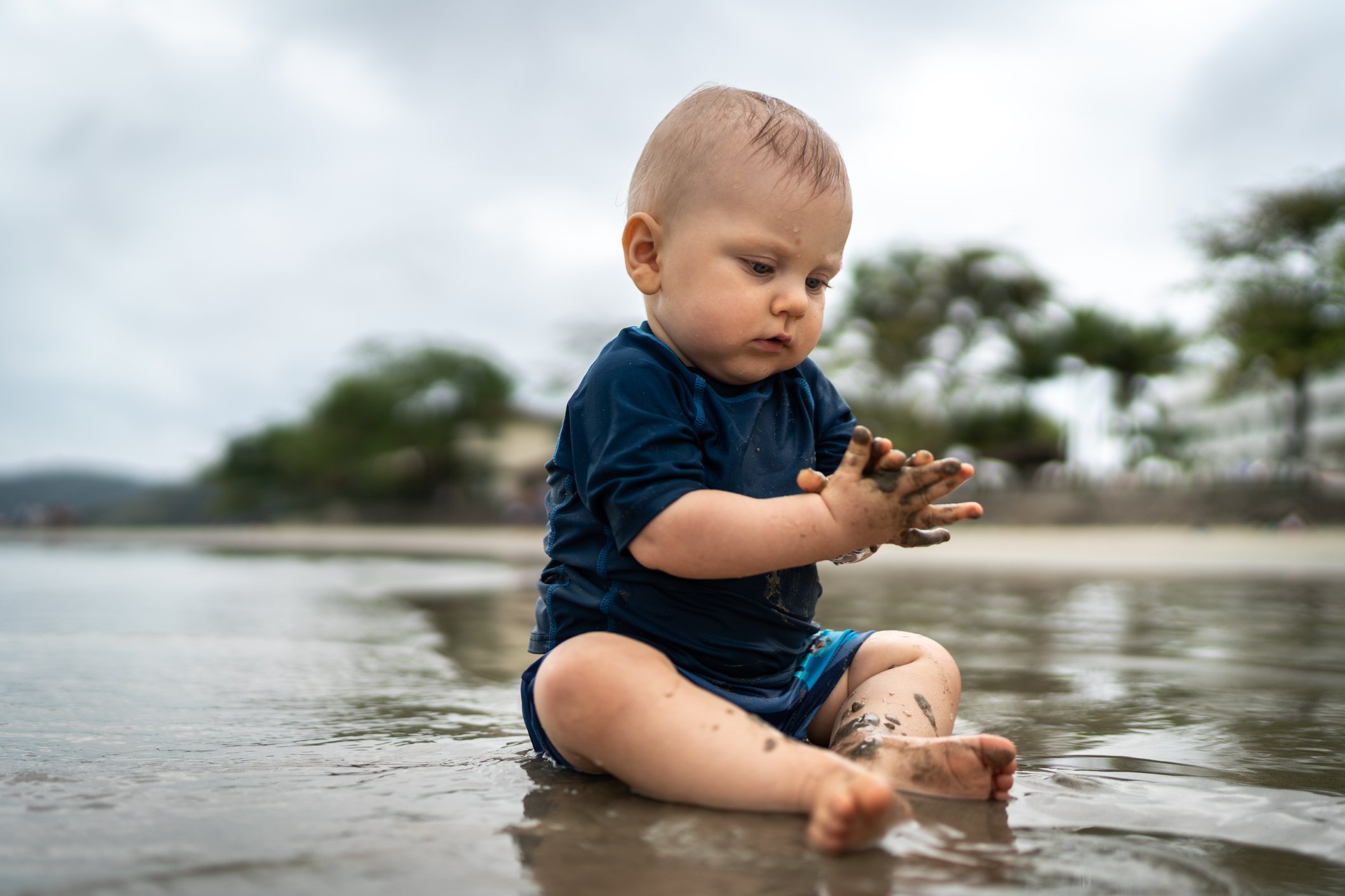 Cute baby playing in the sand at the beach