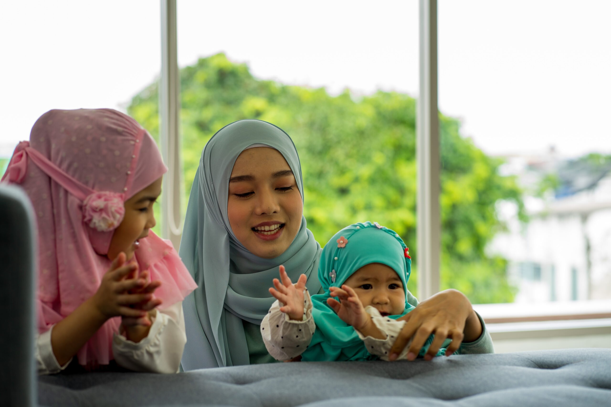 Muslim asian mother and business woman work from home and caring for newborn infant wearing HIJAB work from home new normal