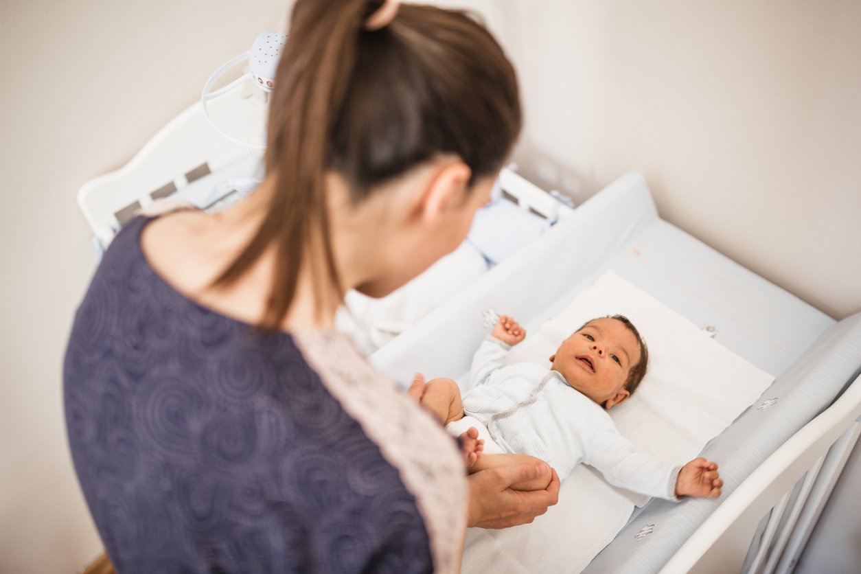 Mother changing diaper of her baby boy
