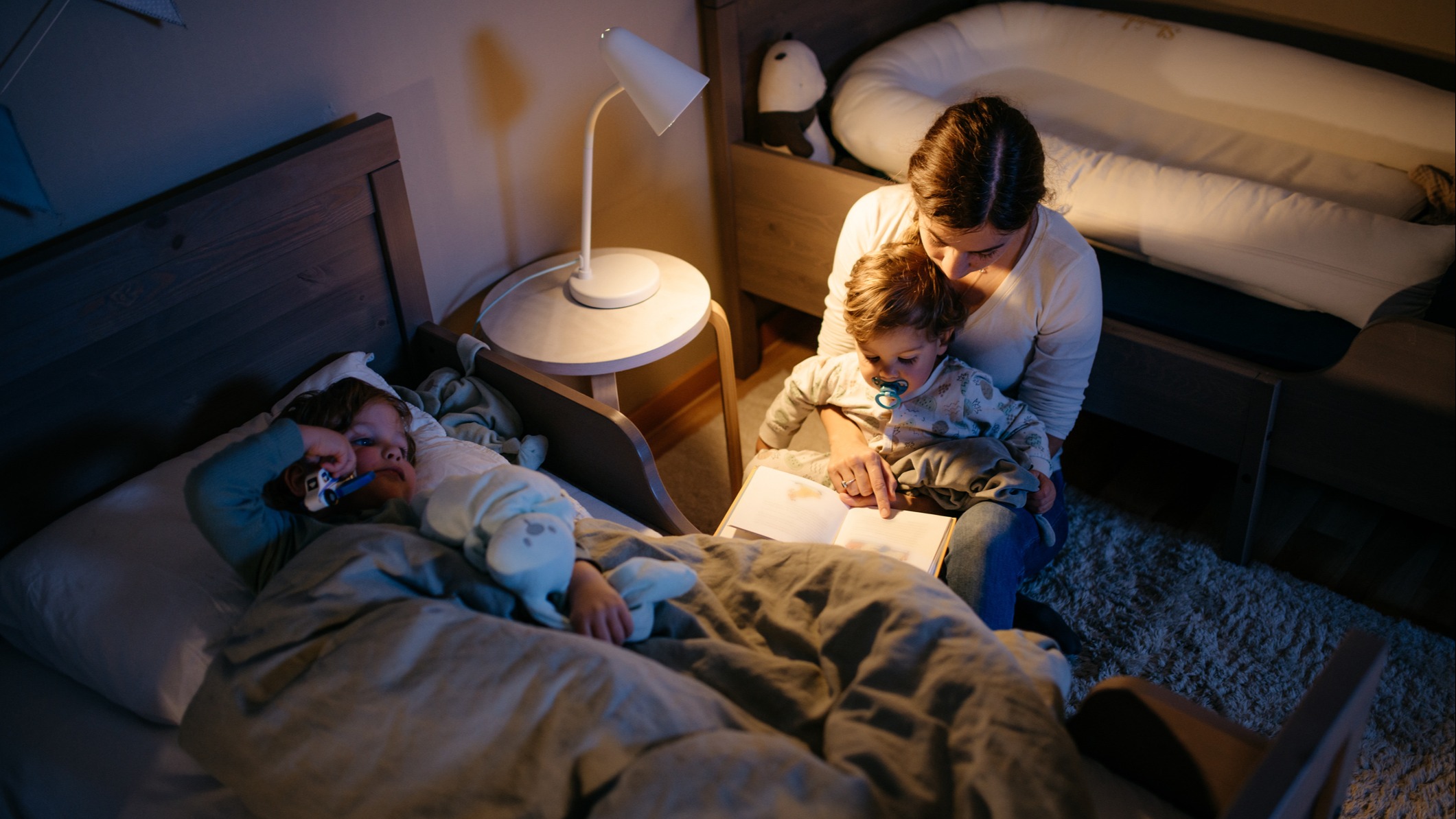 A mom putting her kids to bed
