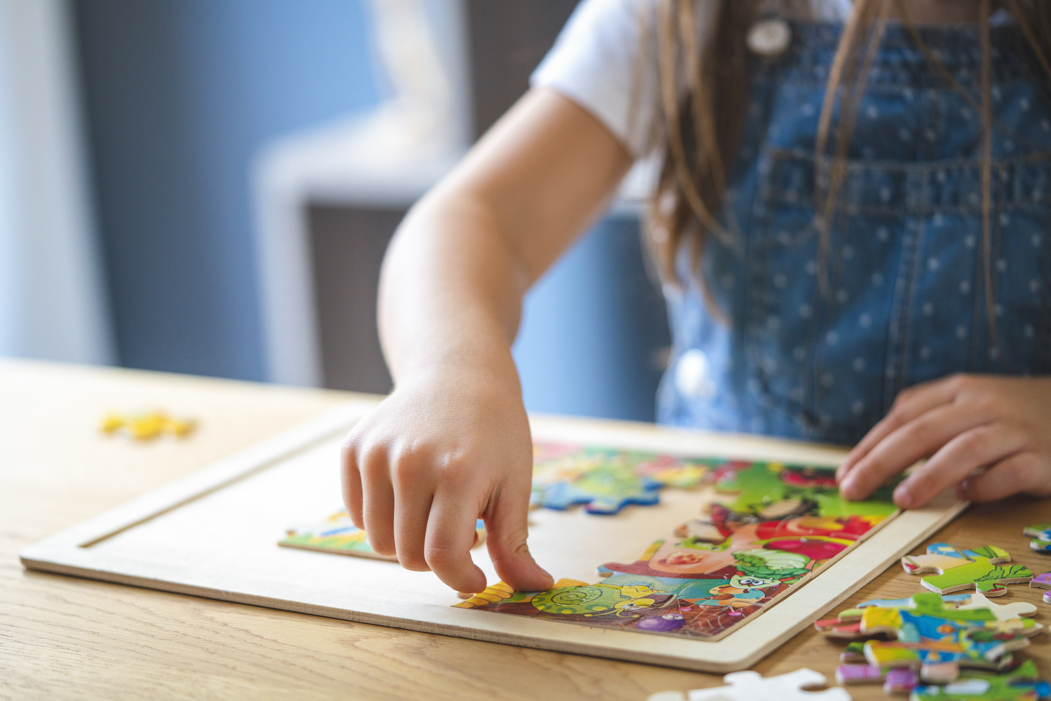 Little girl playing with puzzles at home