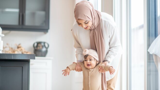 mom helping baby walk