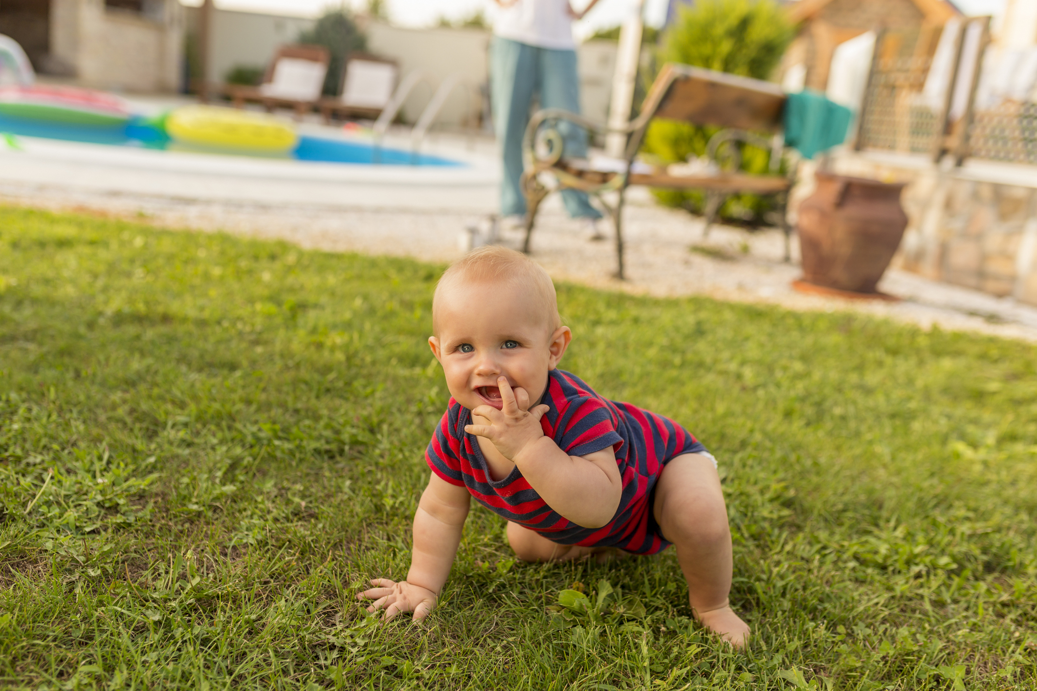 Baby boy crawling on the backyard lawn
