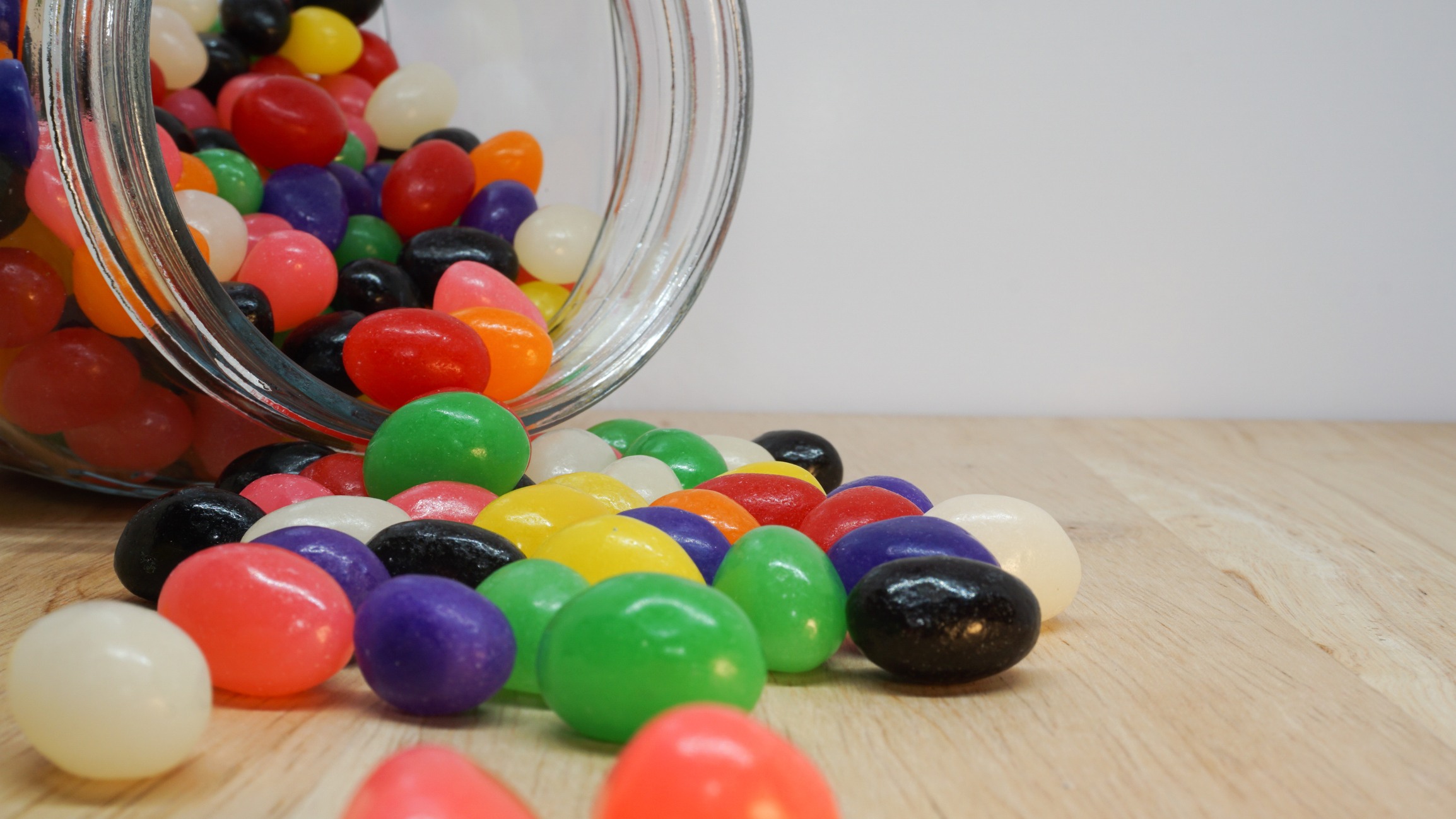 Jelly beans spilling out of a glass jar