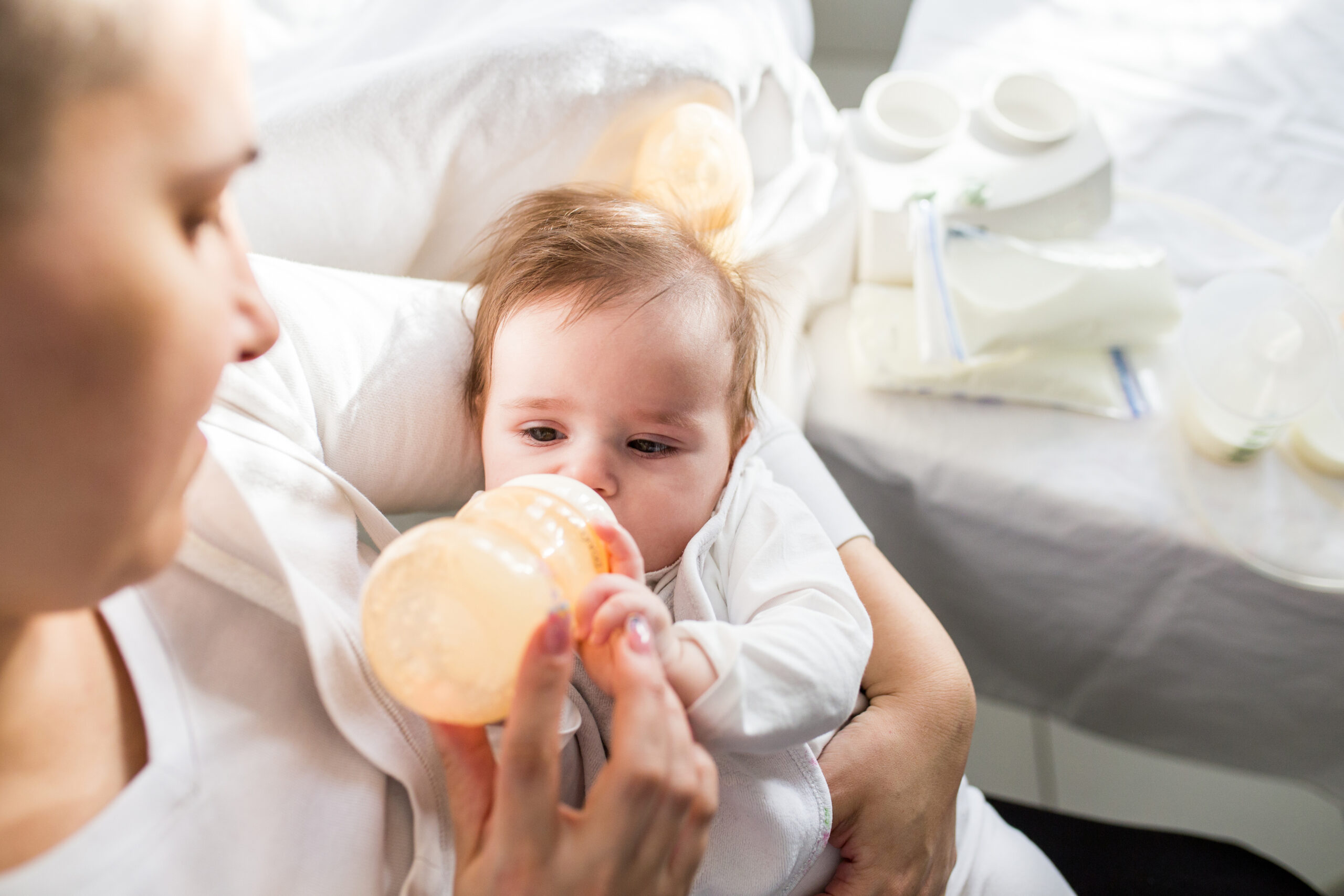 Mother feeding her newborn baby with milk