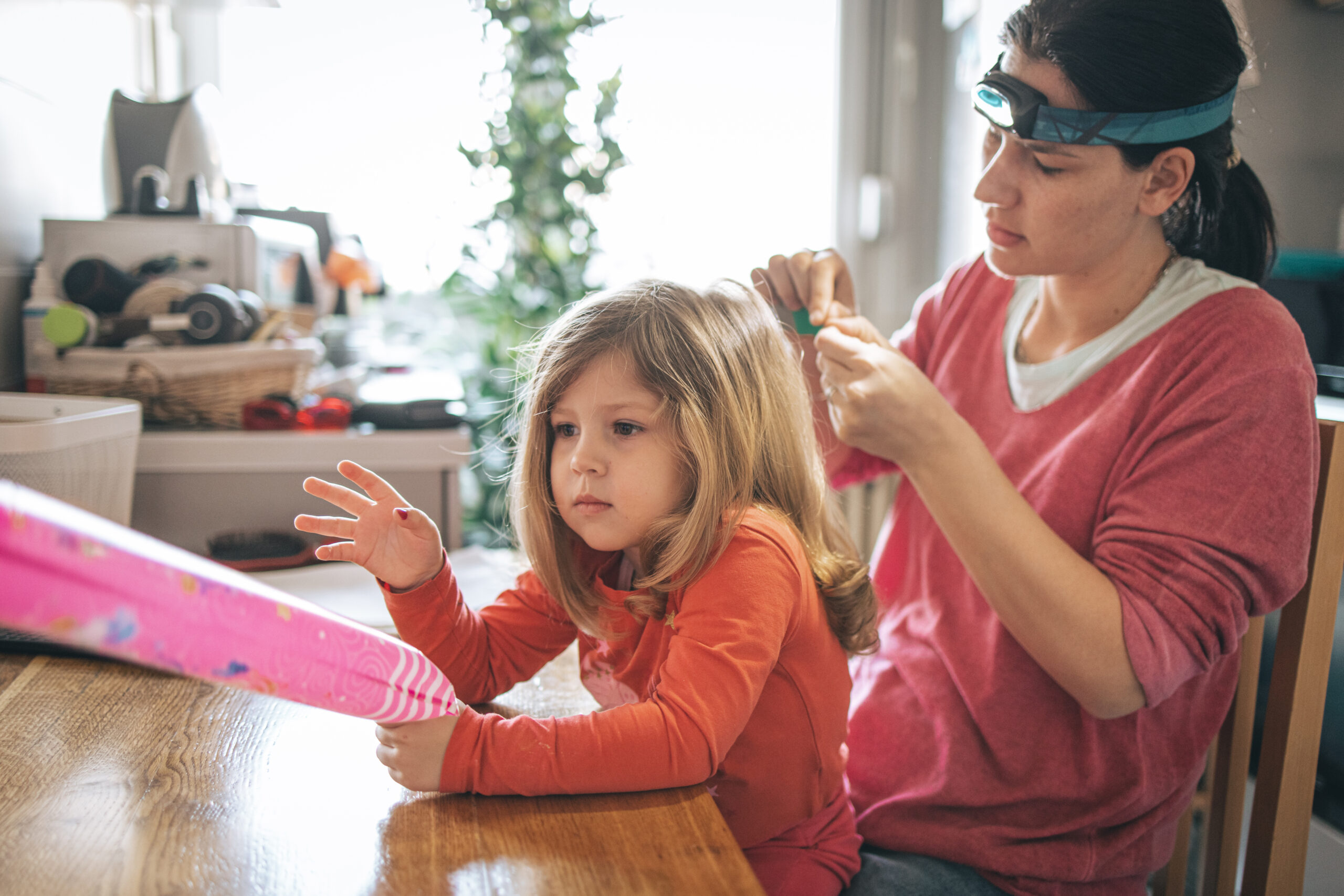 Mother doing head lice Inspection on daughter